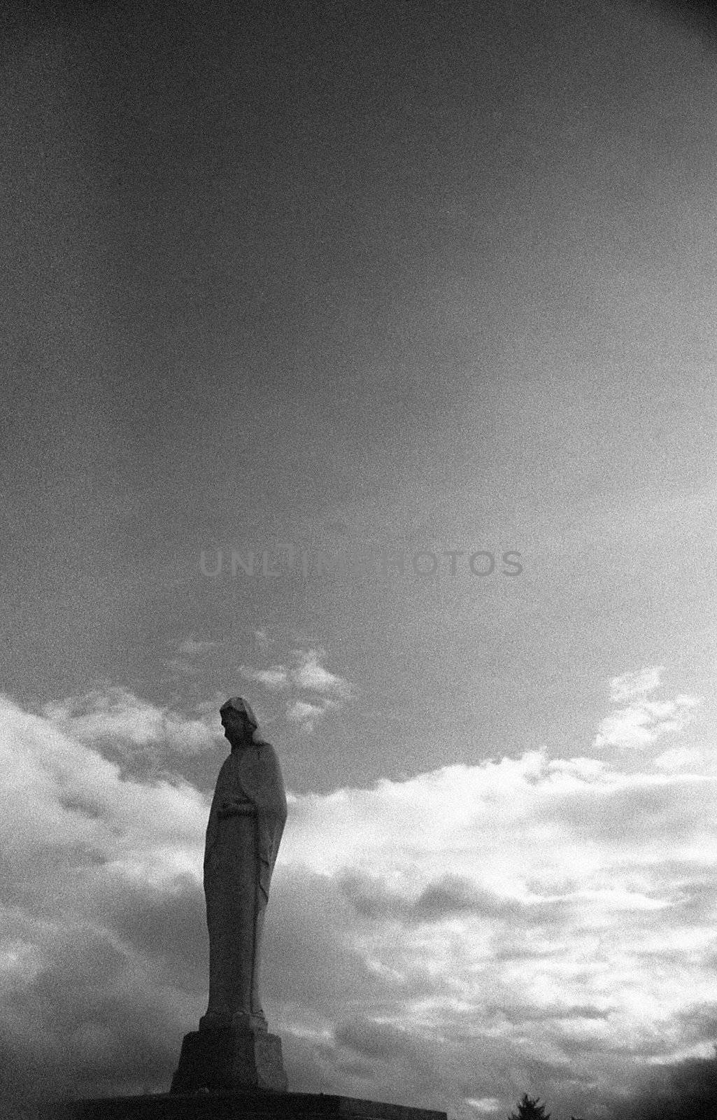 Religious statue of woman against ominous sky