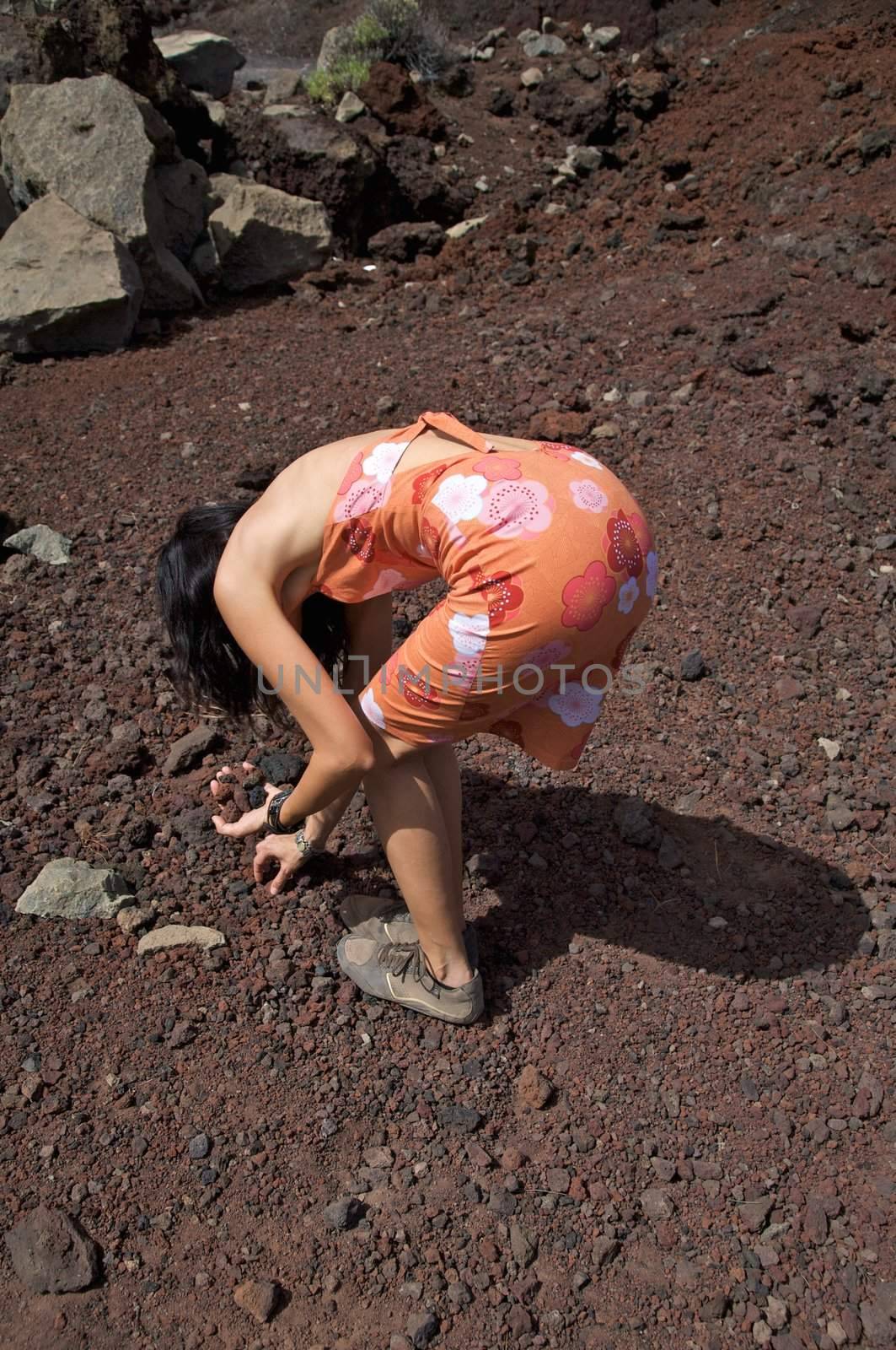 woman picking up volcanic stones in tenerife spain