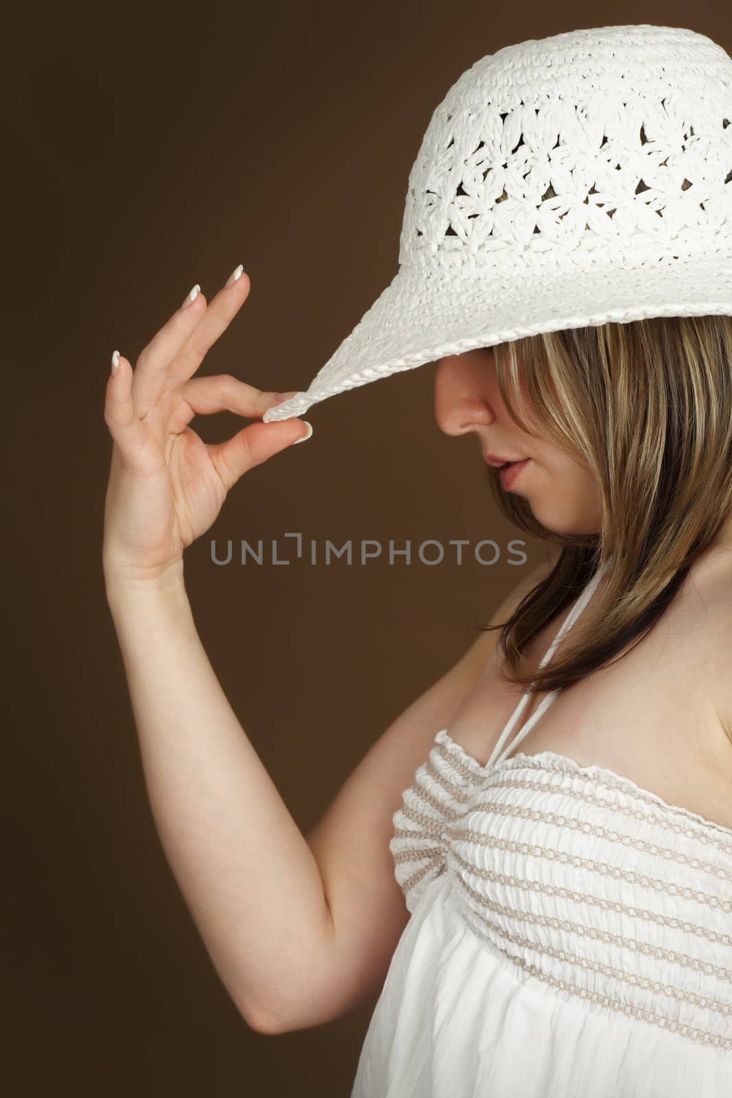 portrait of a woman wearing white hat, brown background