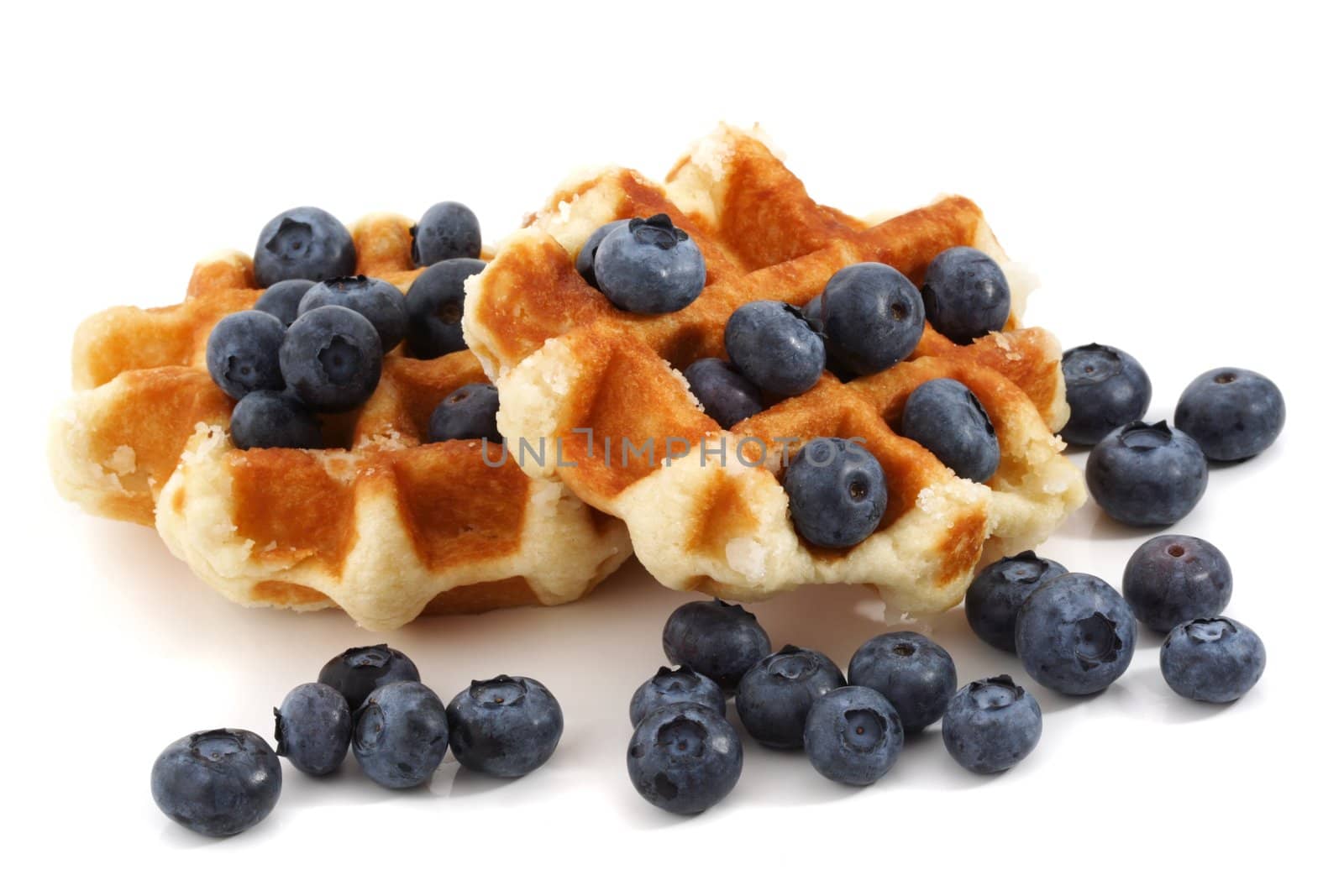 two belgian waffles and fresh blueberries, white background
