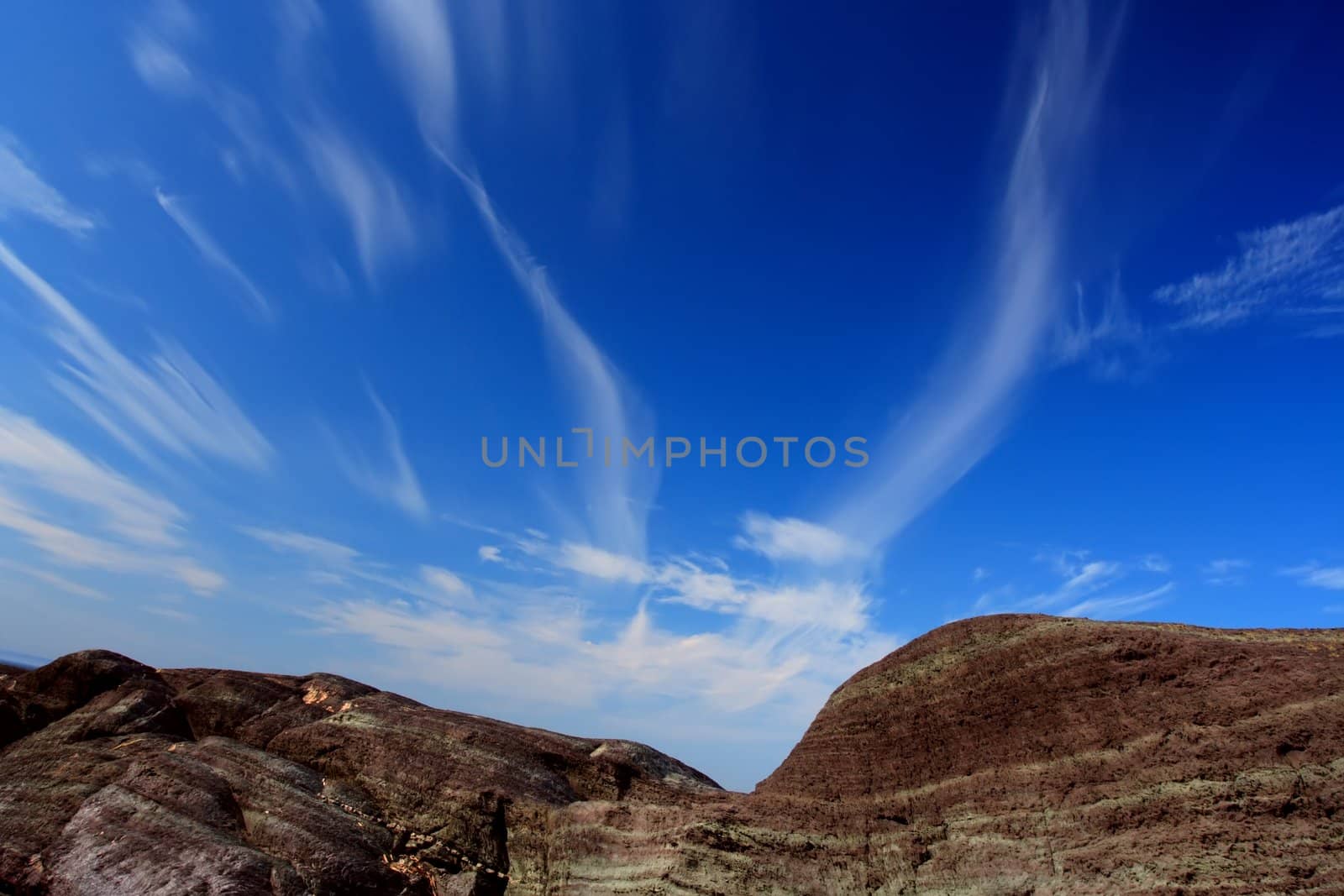landscape with rock and blue cloudy sky
