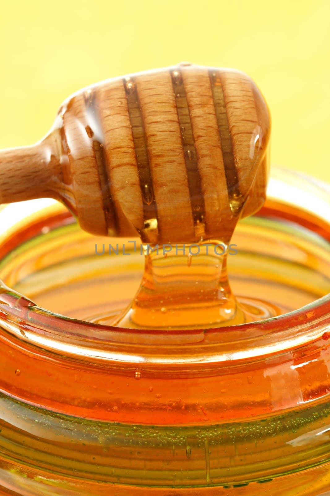 jar of fresh honey with wood stick