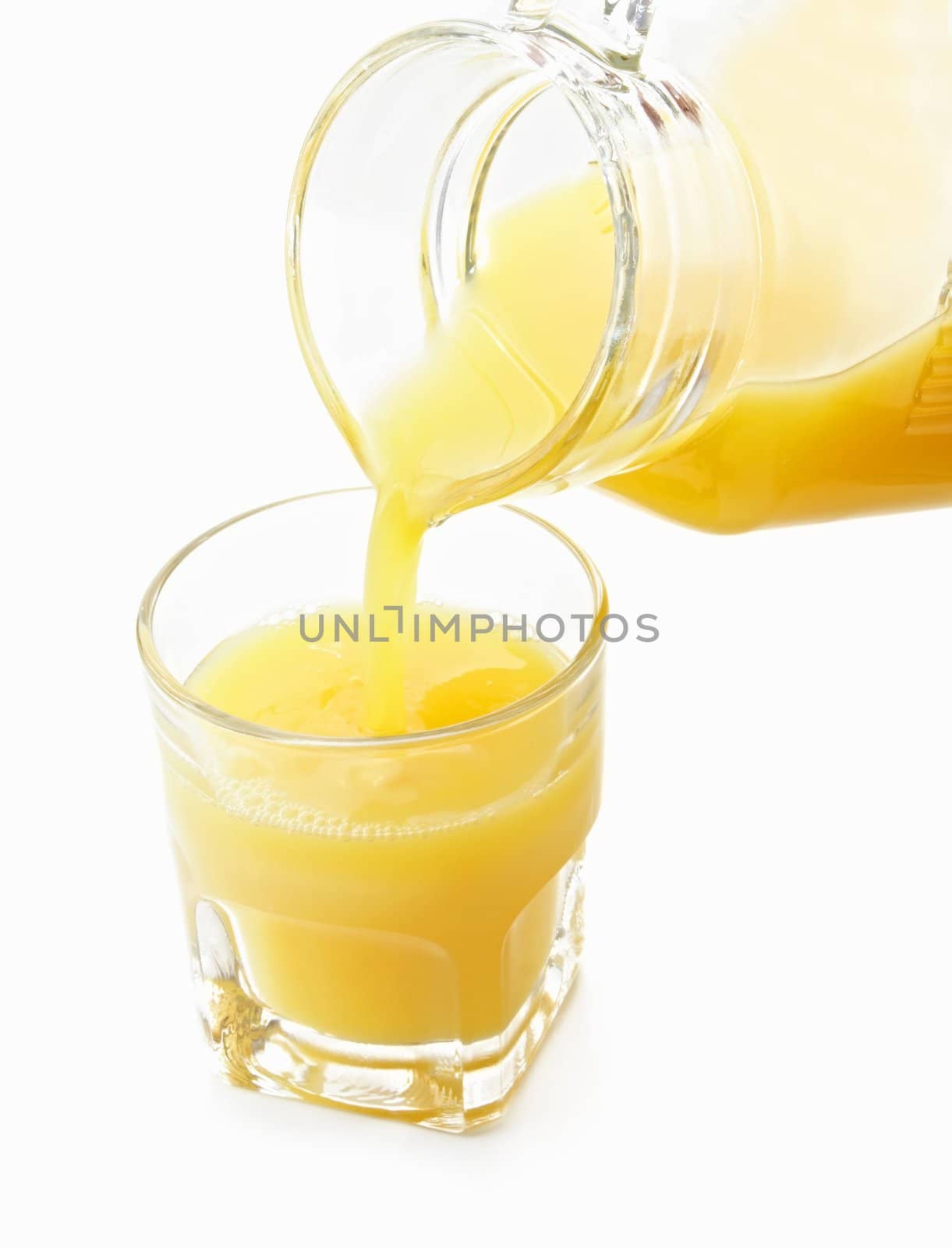 pouring orange juice on a glass, isolated on white