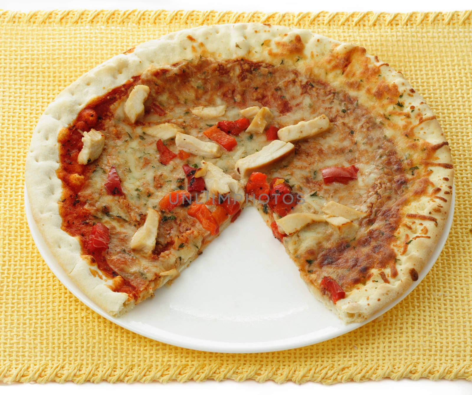 chicken pizza with a slice missing, white plate, yellow tablecloth