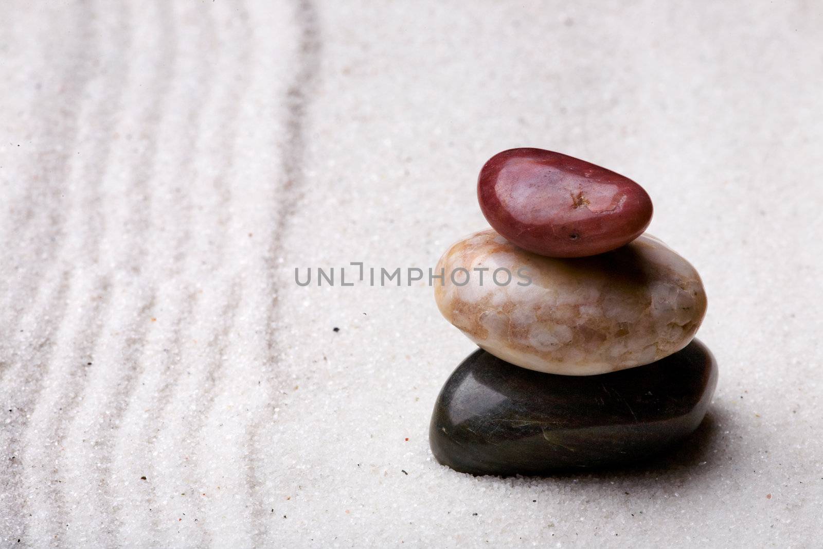 A stack of rocks in a zen rock garden with sand