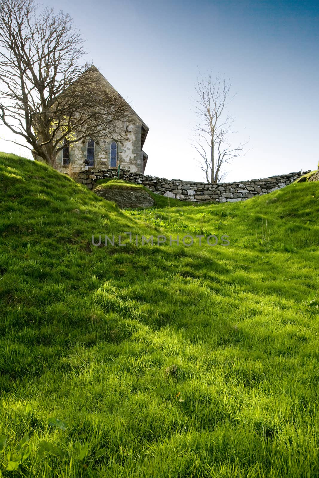 A stone church on a green meadow