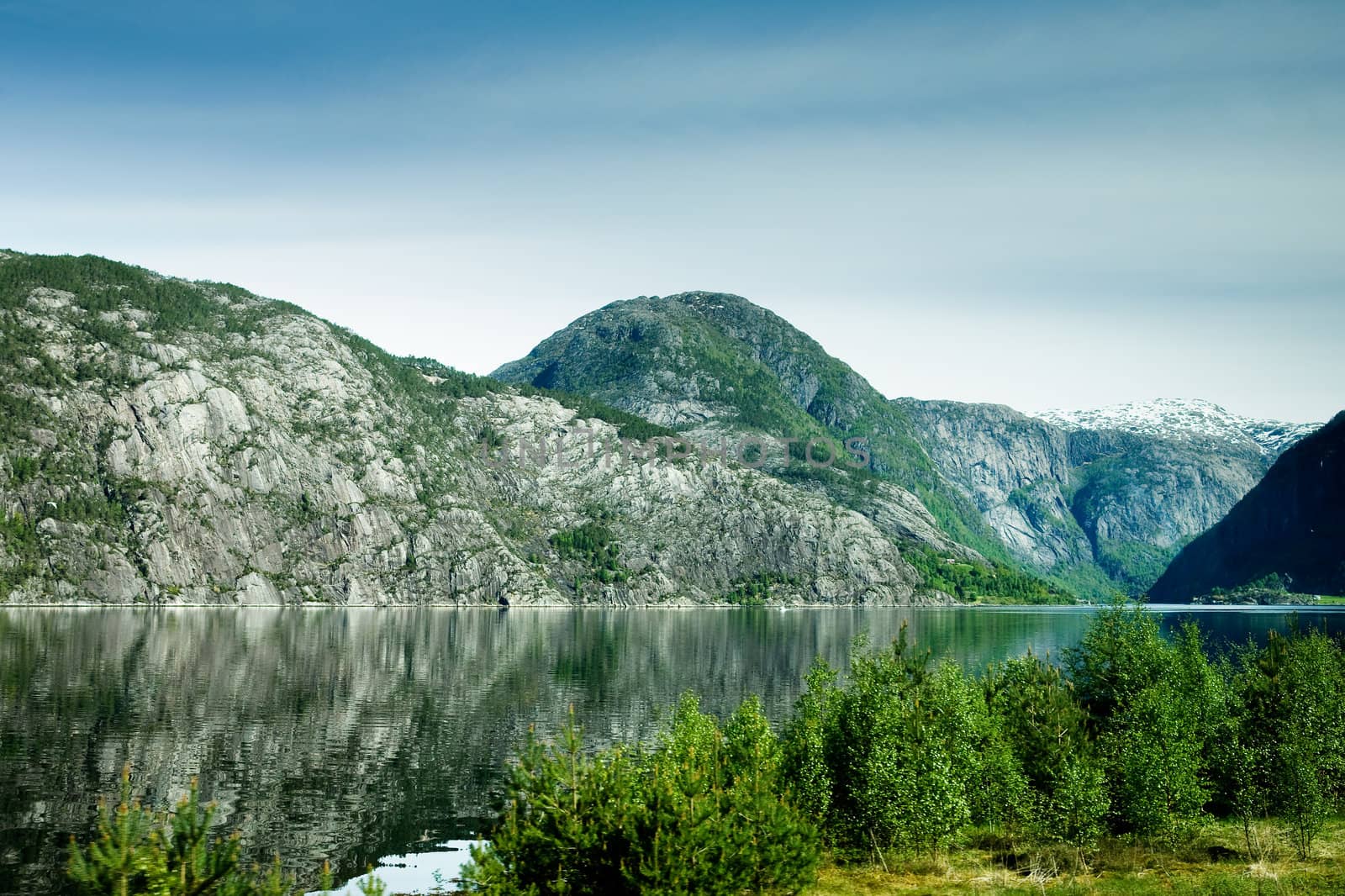 A fjord and rural norway with a blue sky