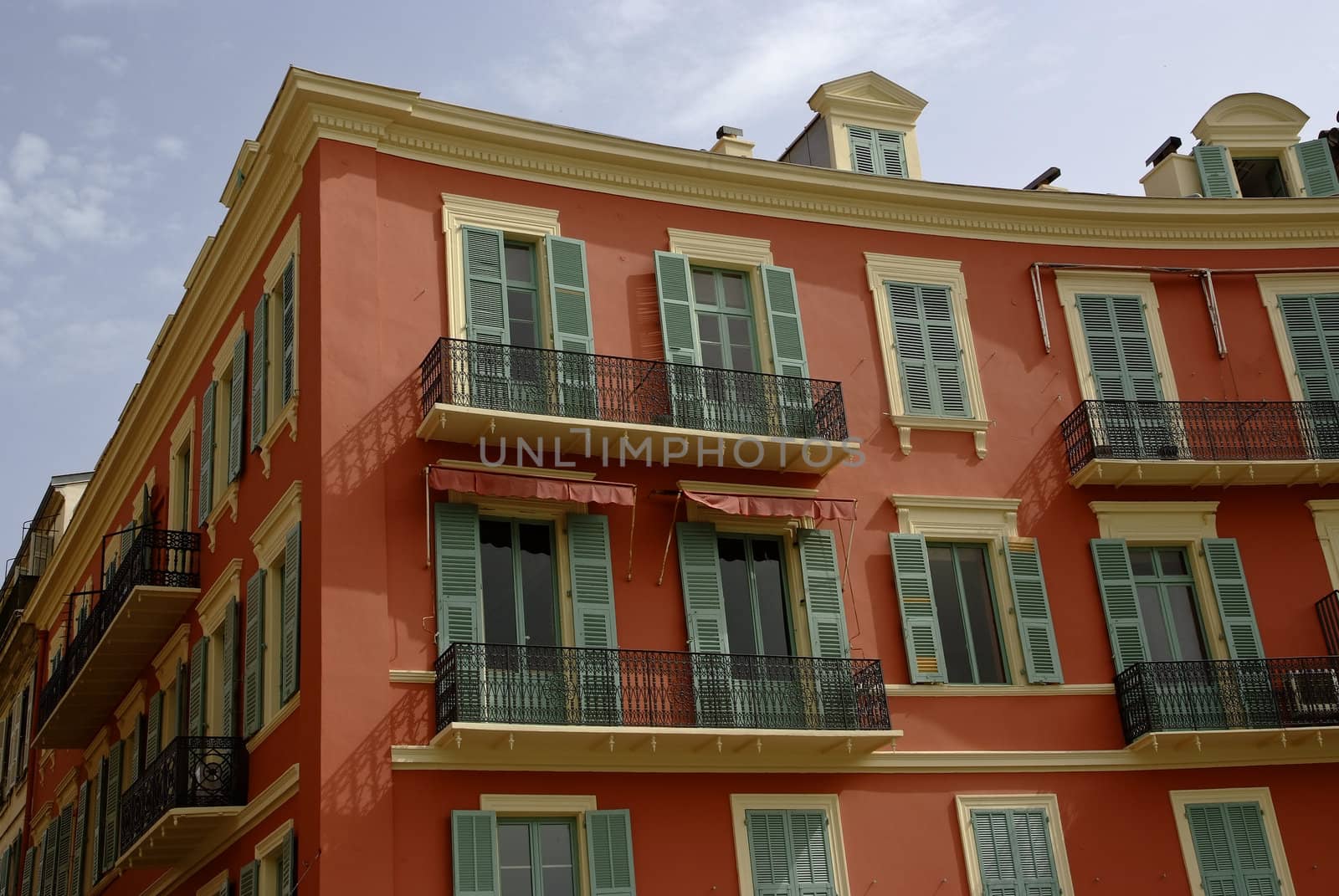 Street view of a typical pastel colored house at the Cote Azur with mediterranean appeal.