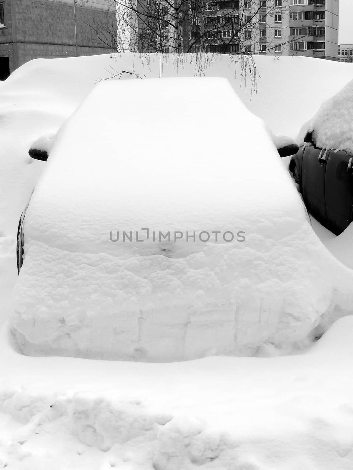 Car with a pile of snow on the top after snowfall
