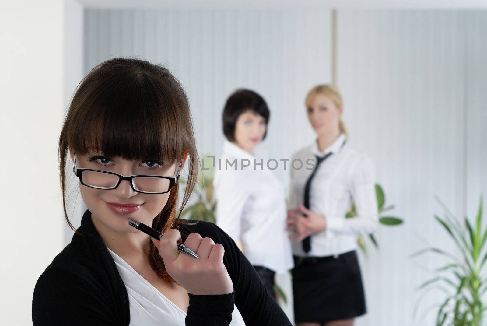  The young business woman at office with colleagues 

