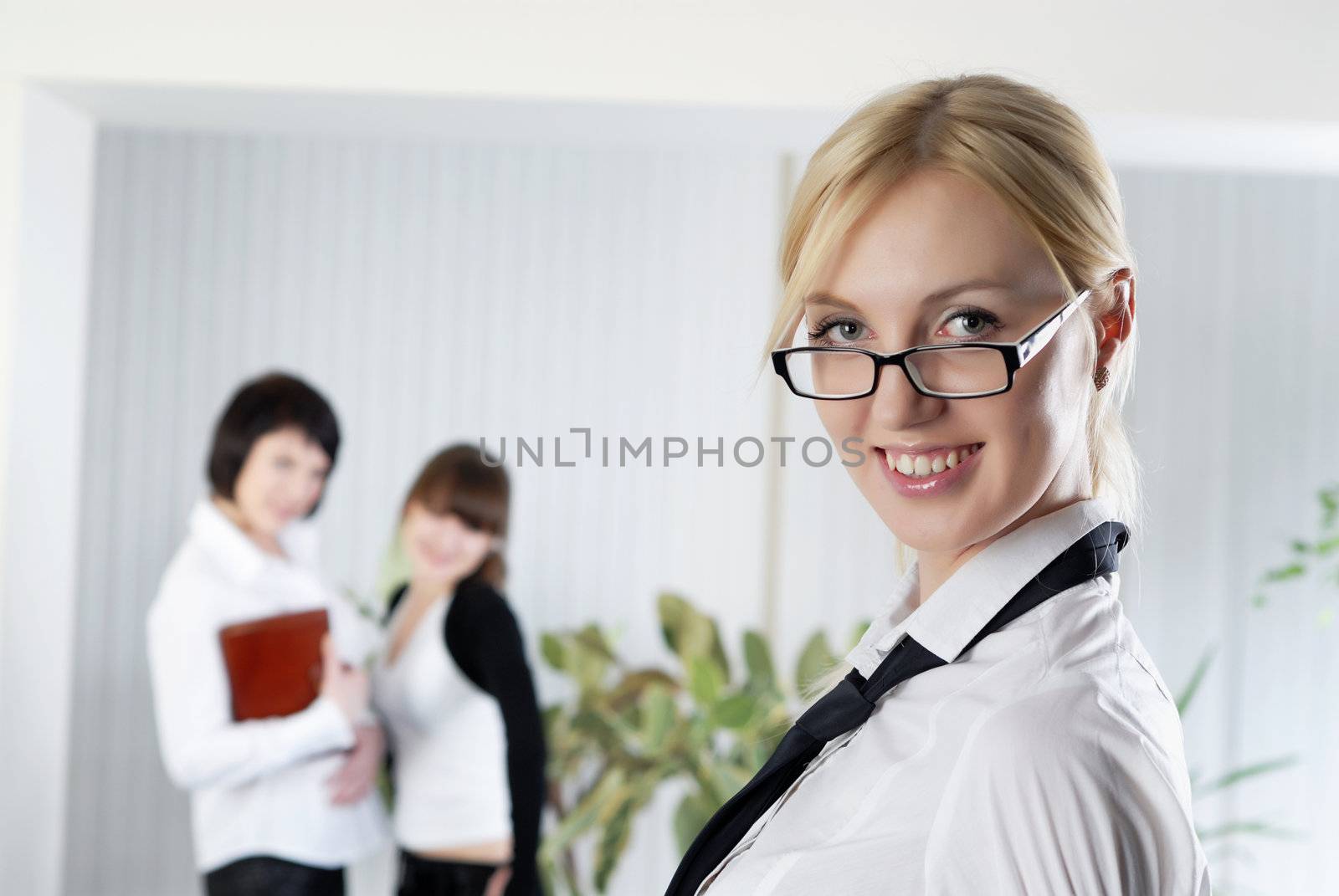  The young business woman at office with colleagues  by Baronerosso