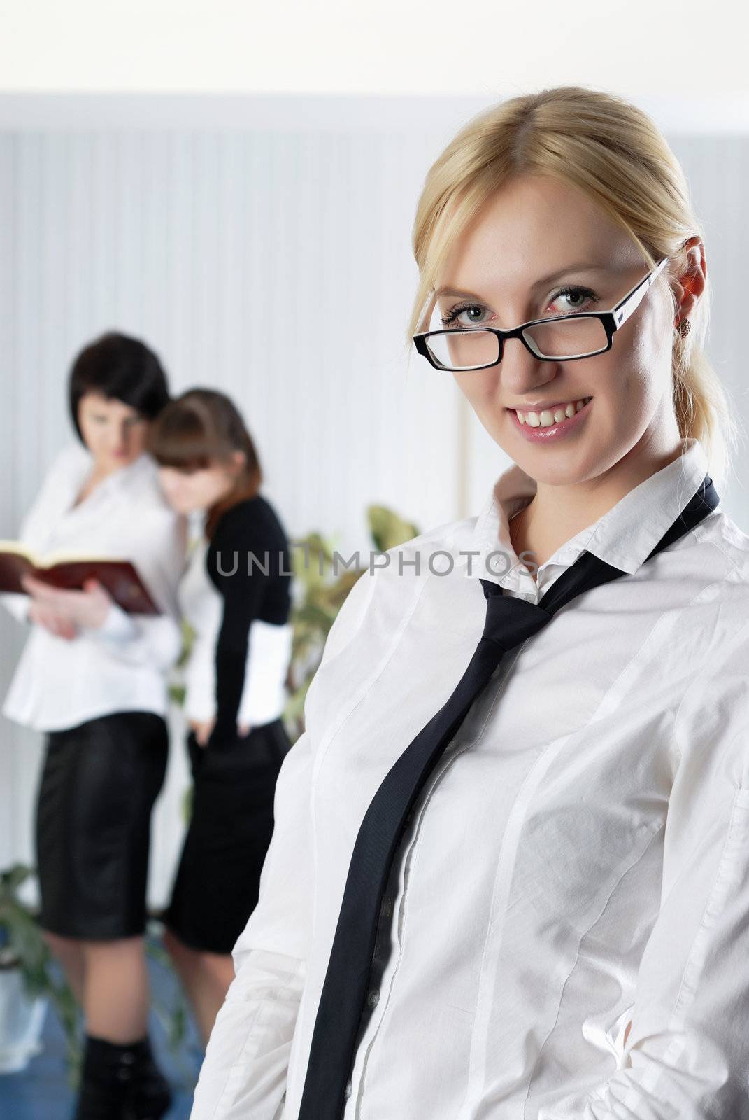  The young business woman at office with colleagues  by Baronerosso