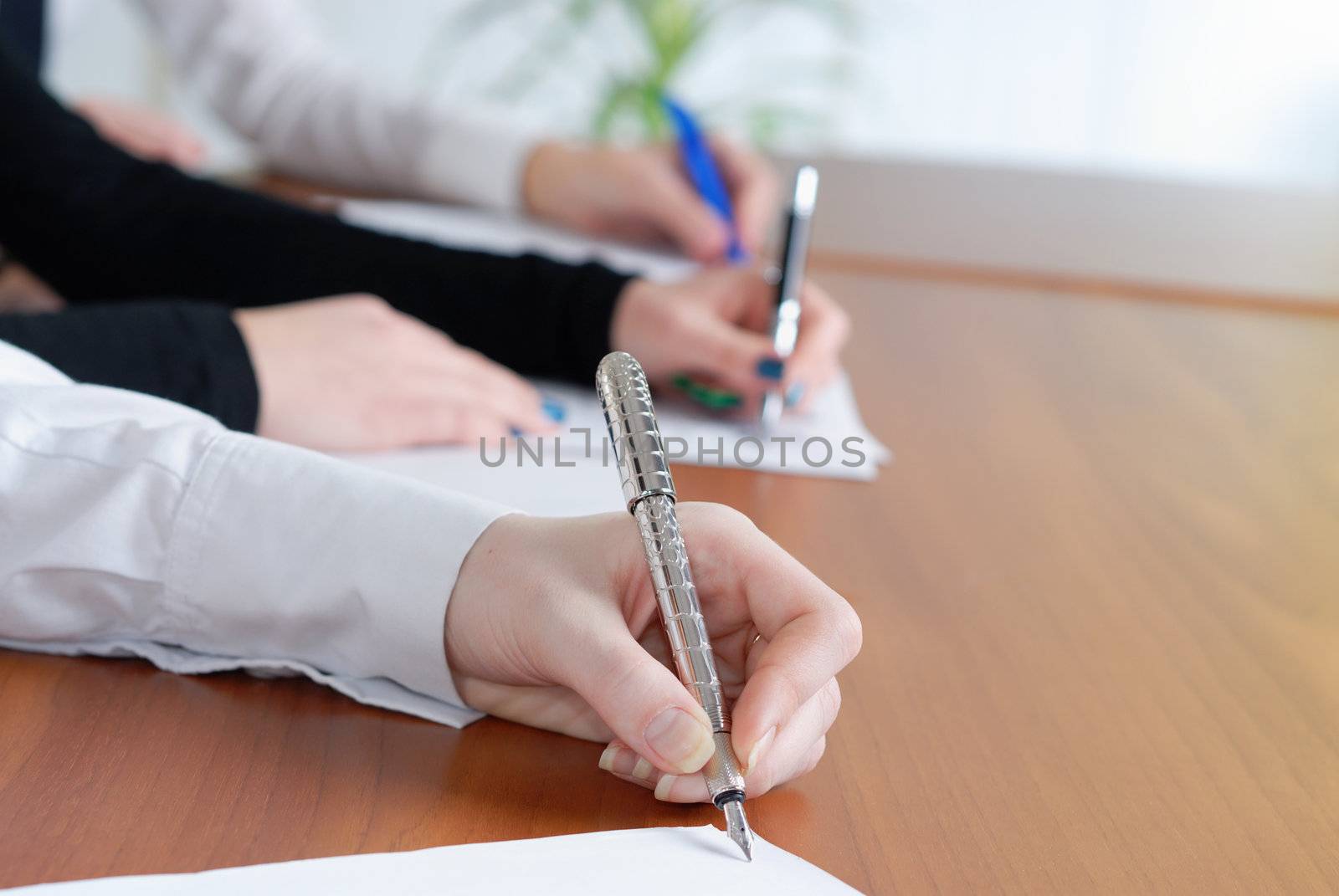 person's hand signing an important document