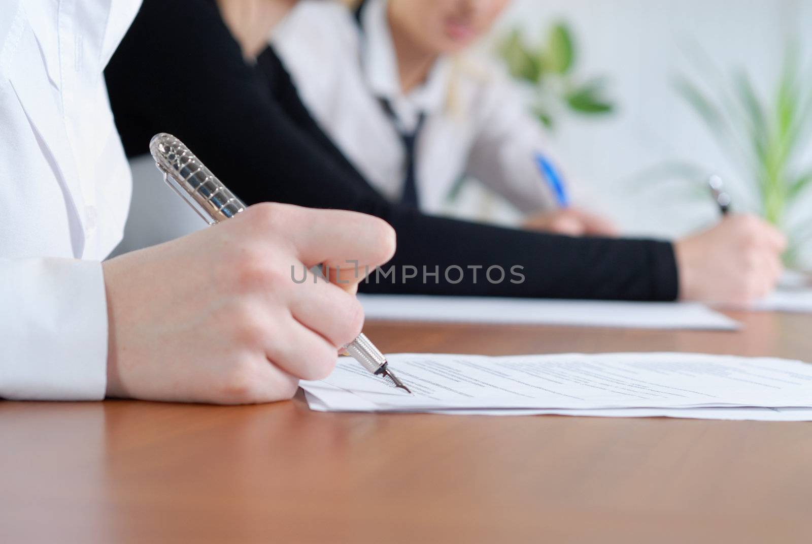 person's hand signing an important document