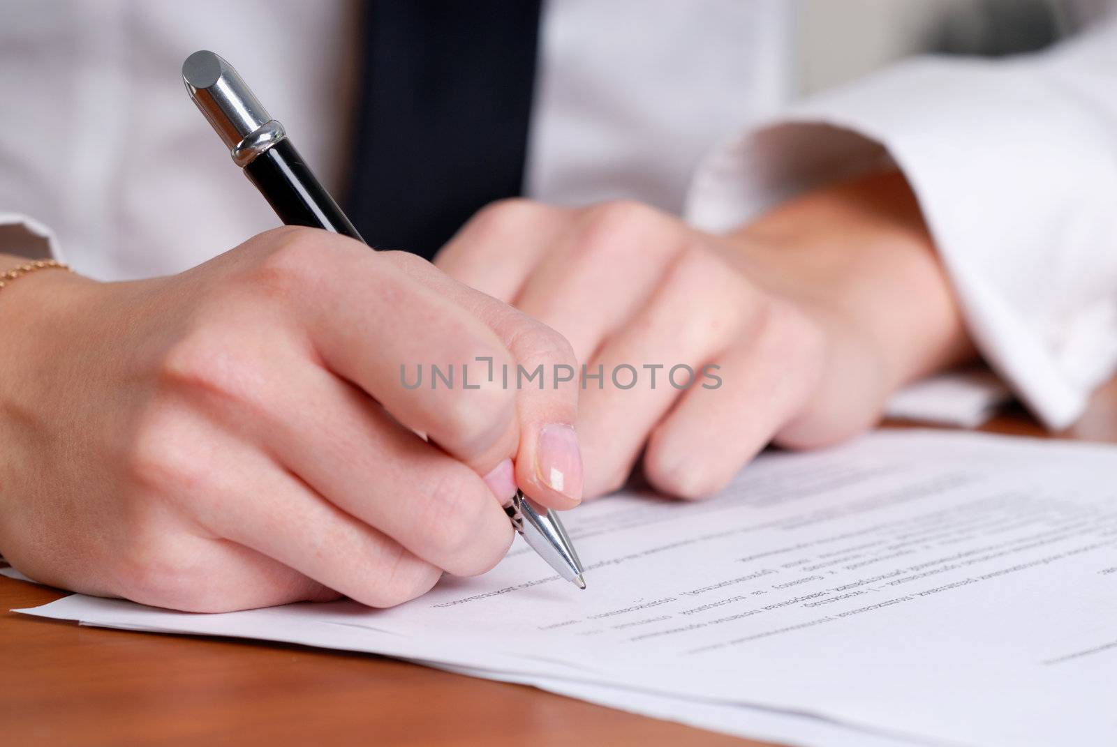 person's hand signing an important document by Baronerosso
