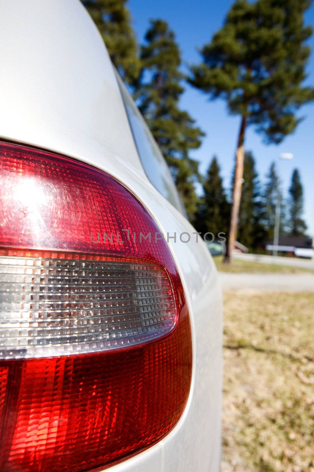 A red and white rear car light with sun reflection