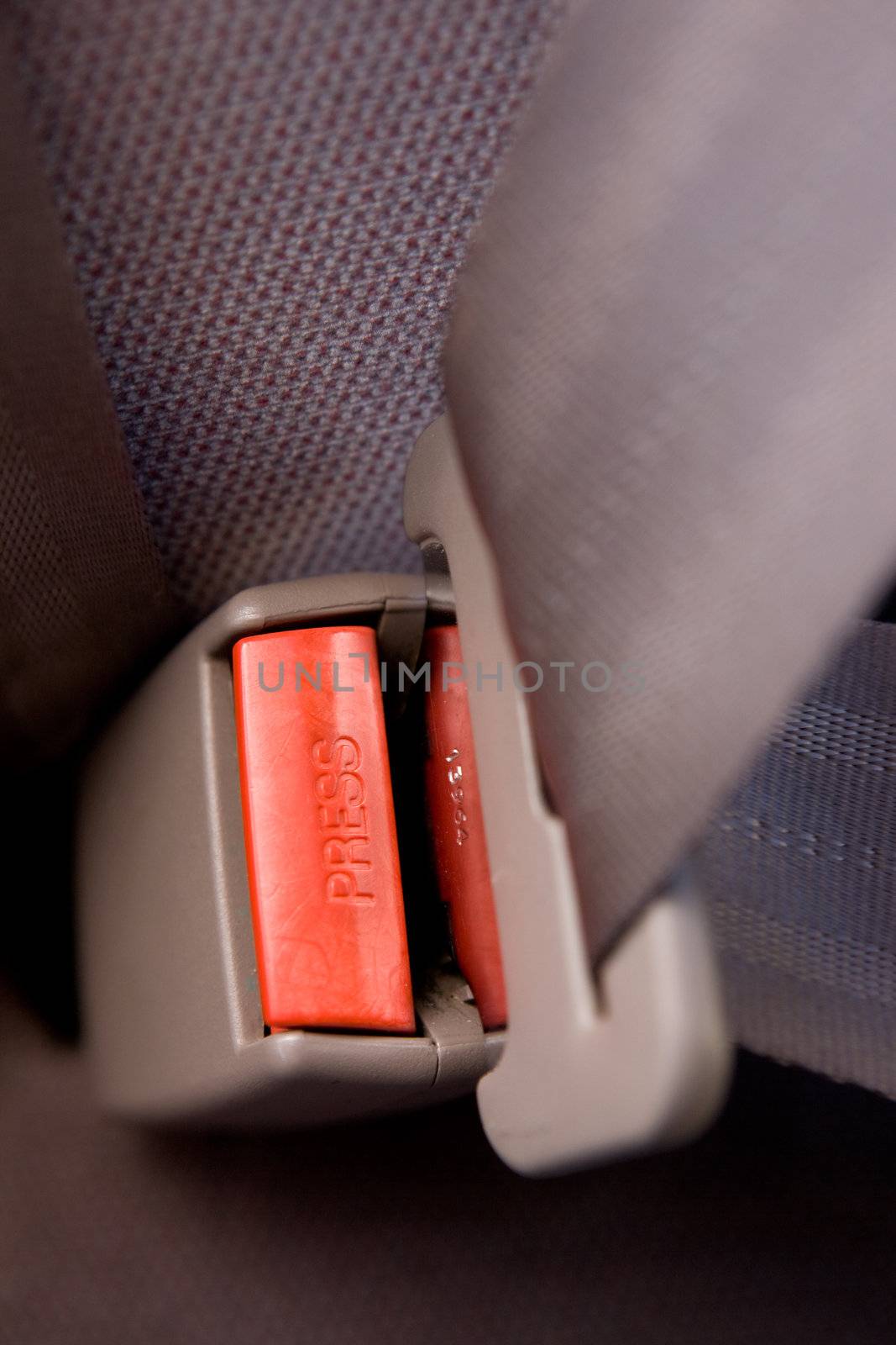A seatbelt in a car with cloth seats