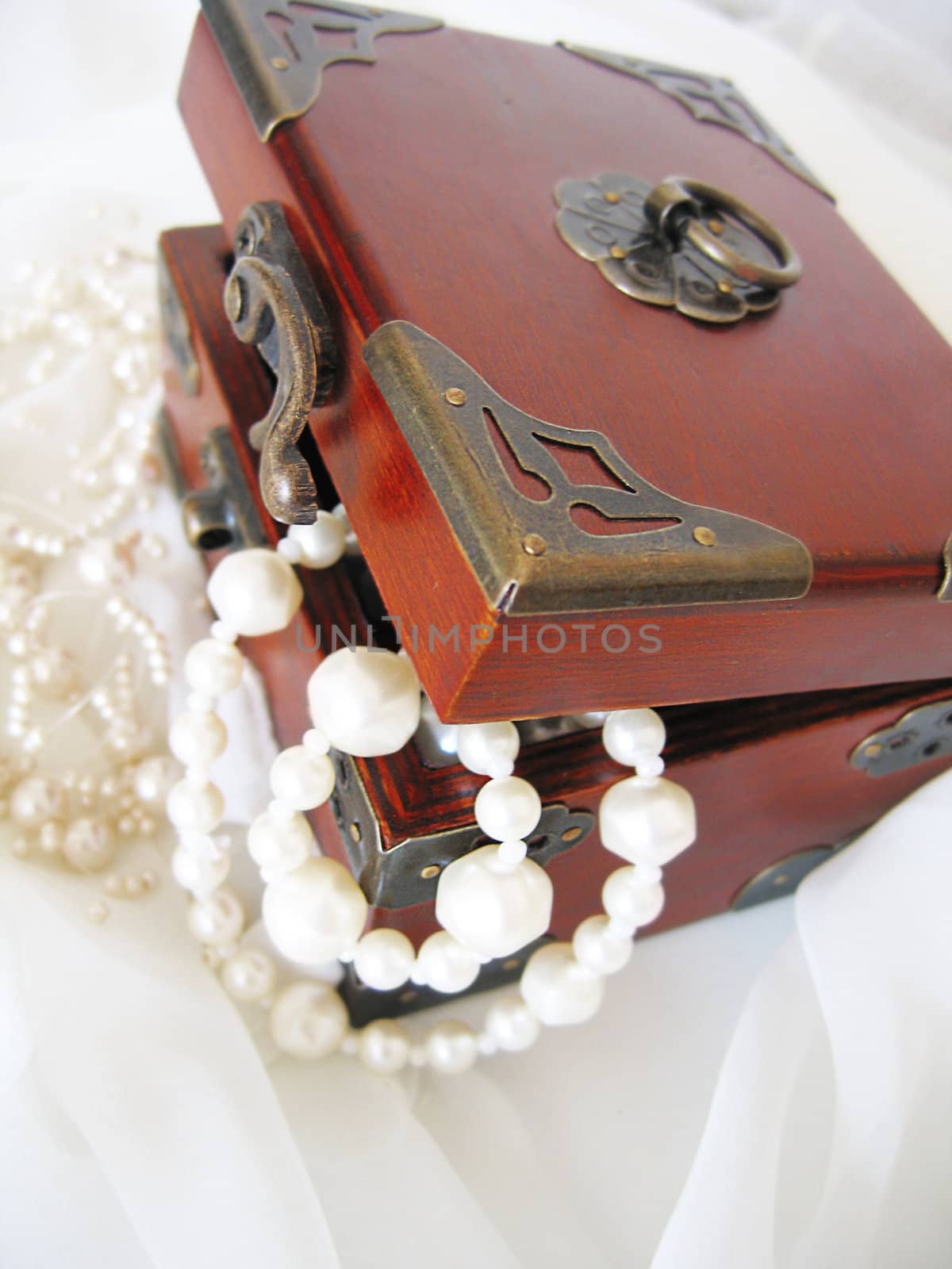 Casket of of pearl necklace on white material