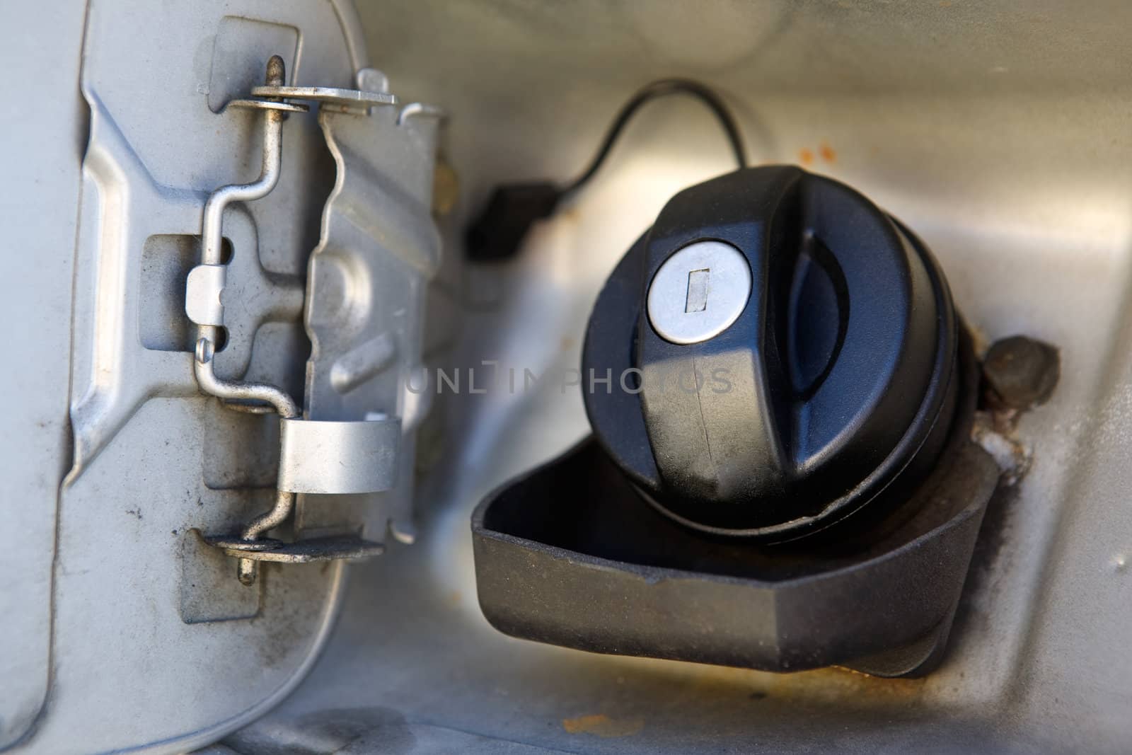 A fuel cap tank on a car open and ready for filling