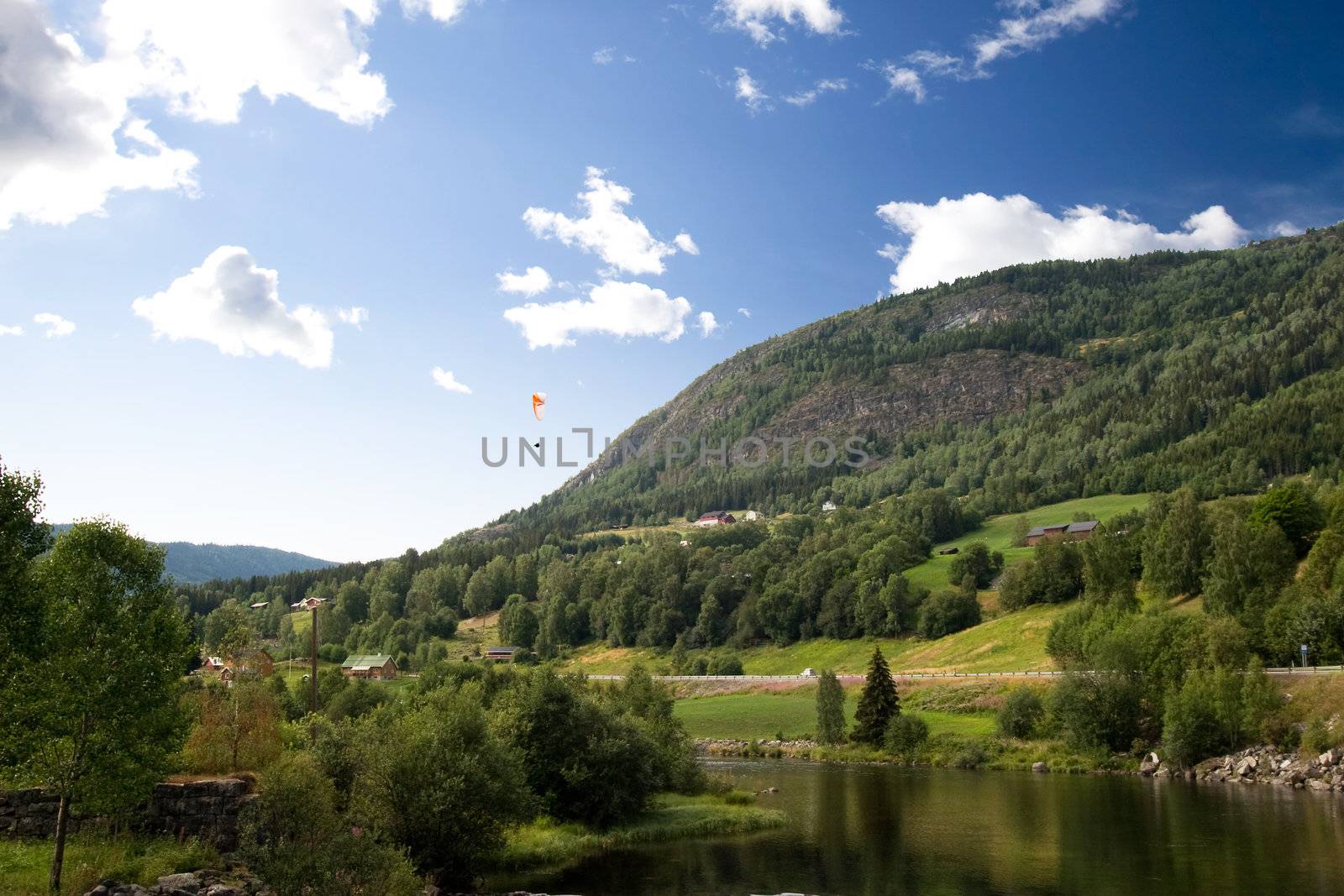 A Norwegian mountain landscape with a parachute in the sky