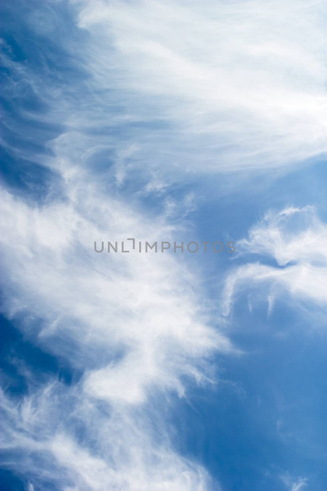A cloud abstrct background image with whistful clouds and a deep blue sky