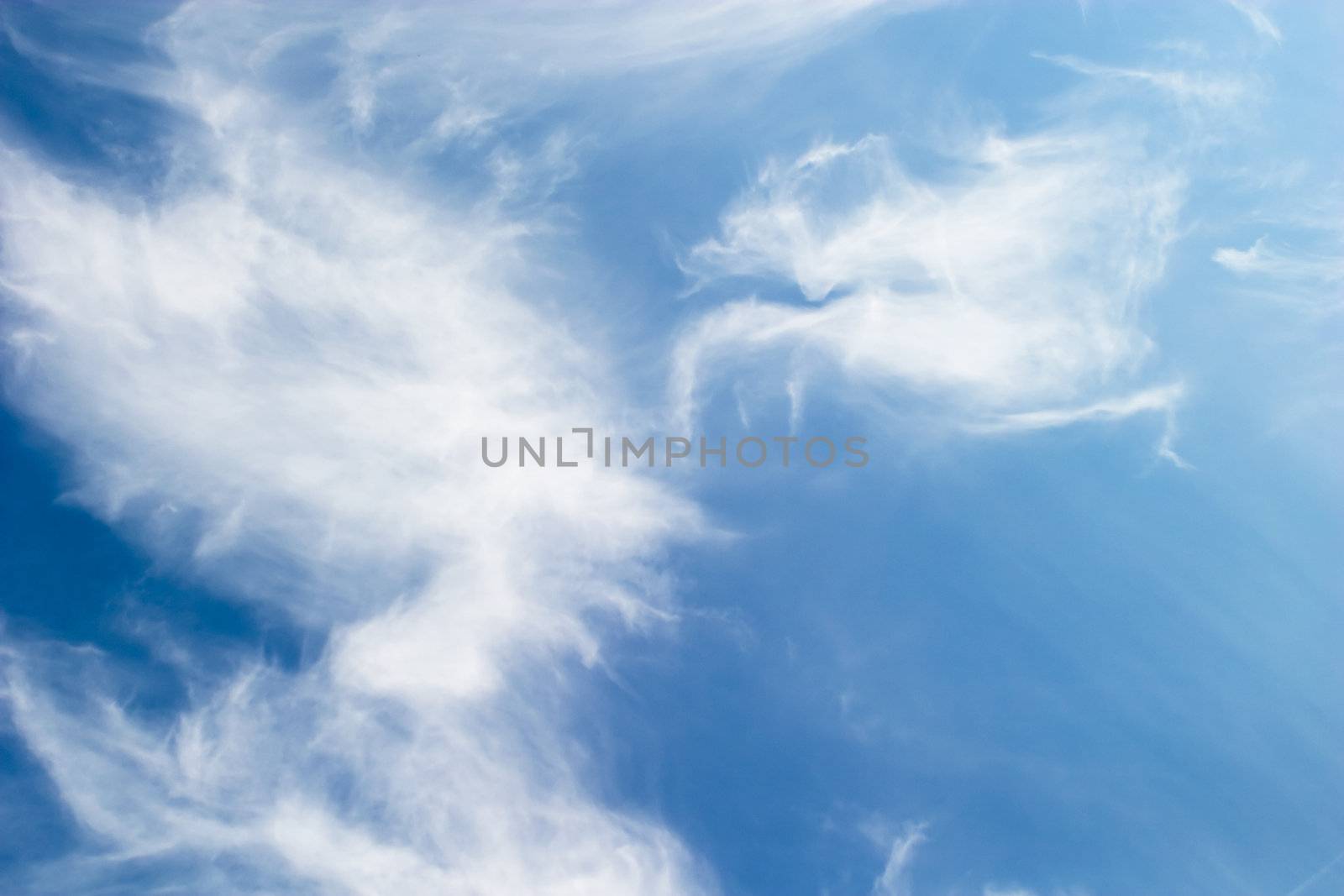 A cloud abstrct background image with whistful clouds and a deep blue sky