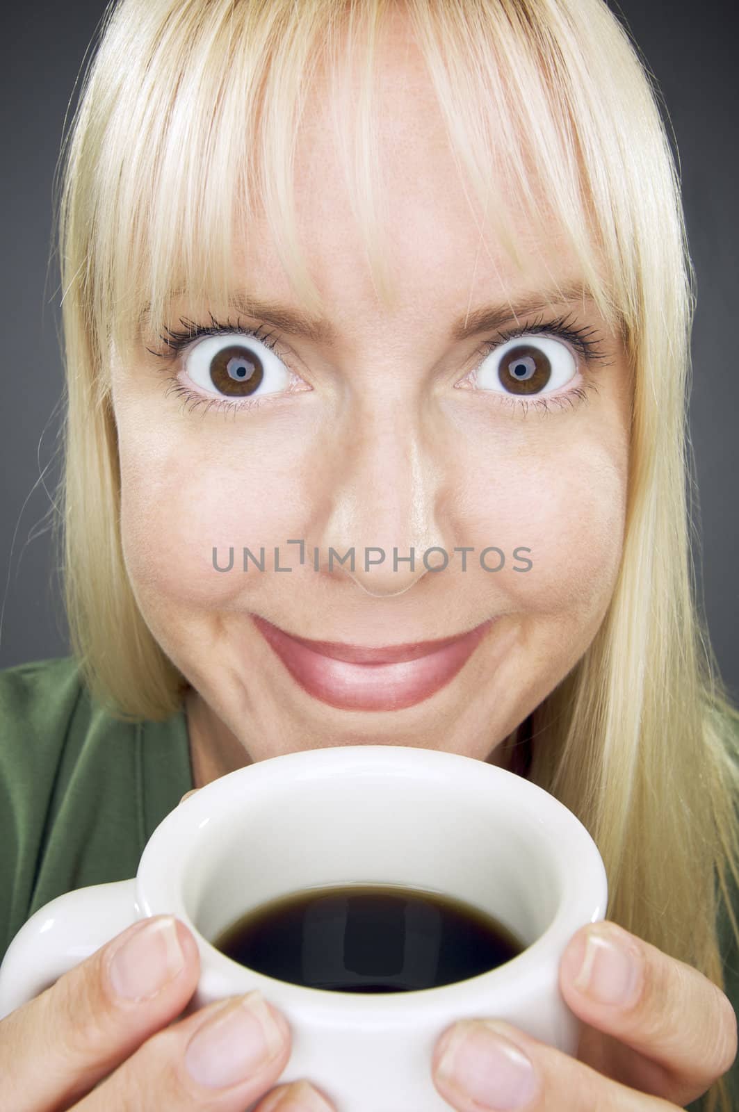 Beautiful Woman Enjoys Her Coffee Against a Grey Background.