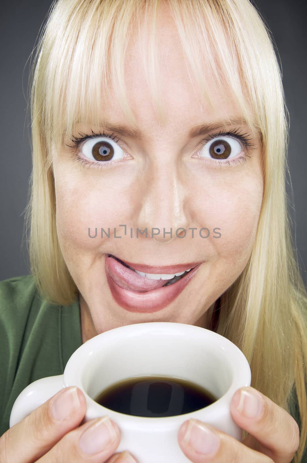 Beautiful Woman Enjoys Her Coffee Against a Grey Background.