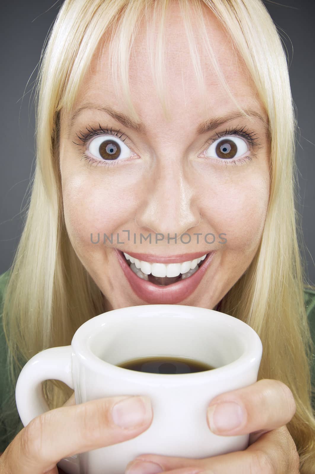 Beautiful Woman Enjoys Her Coffee Against a Grey Background.