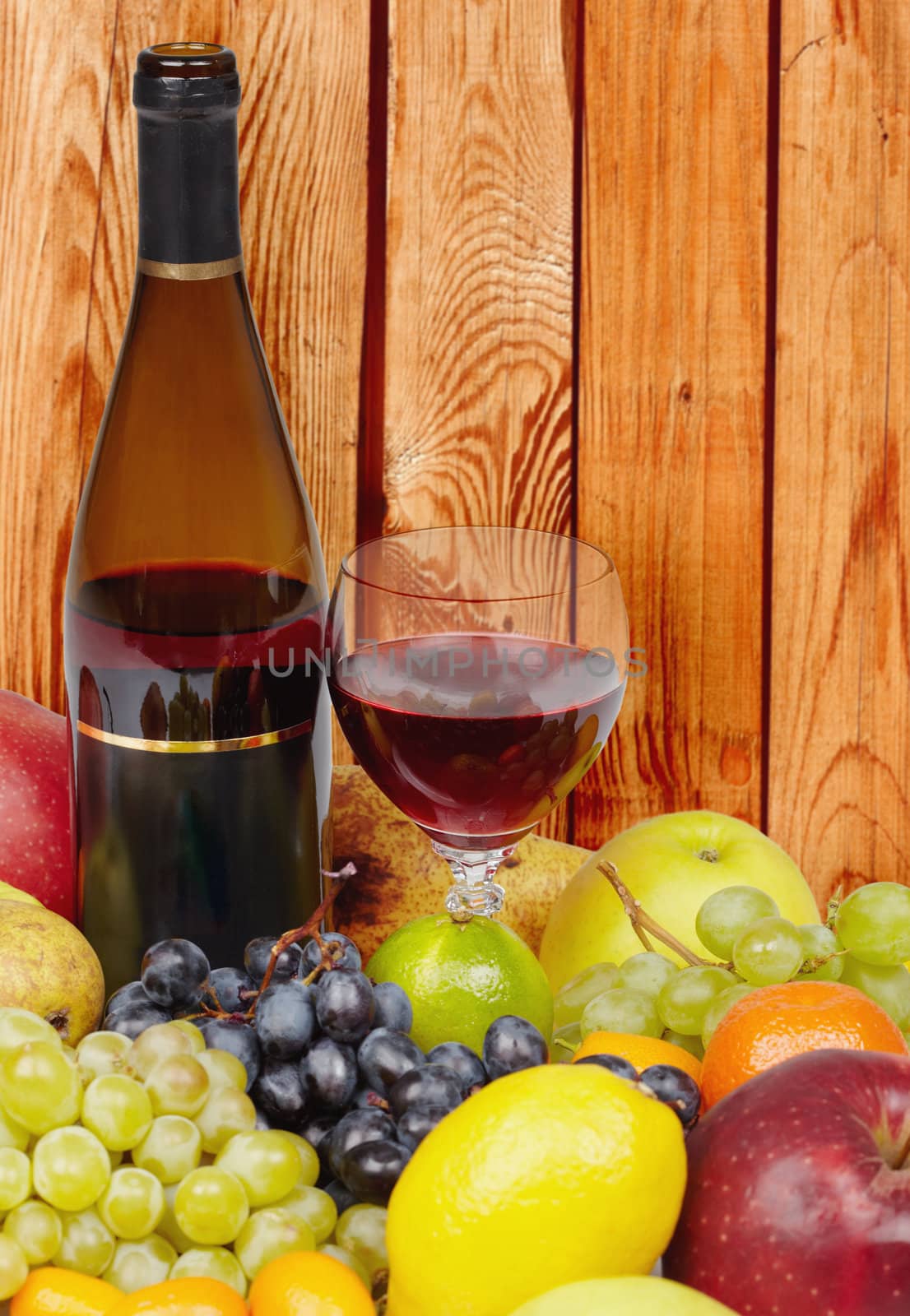 Wine and fruits on a background of wooden wall