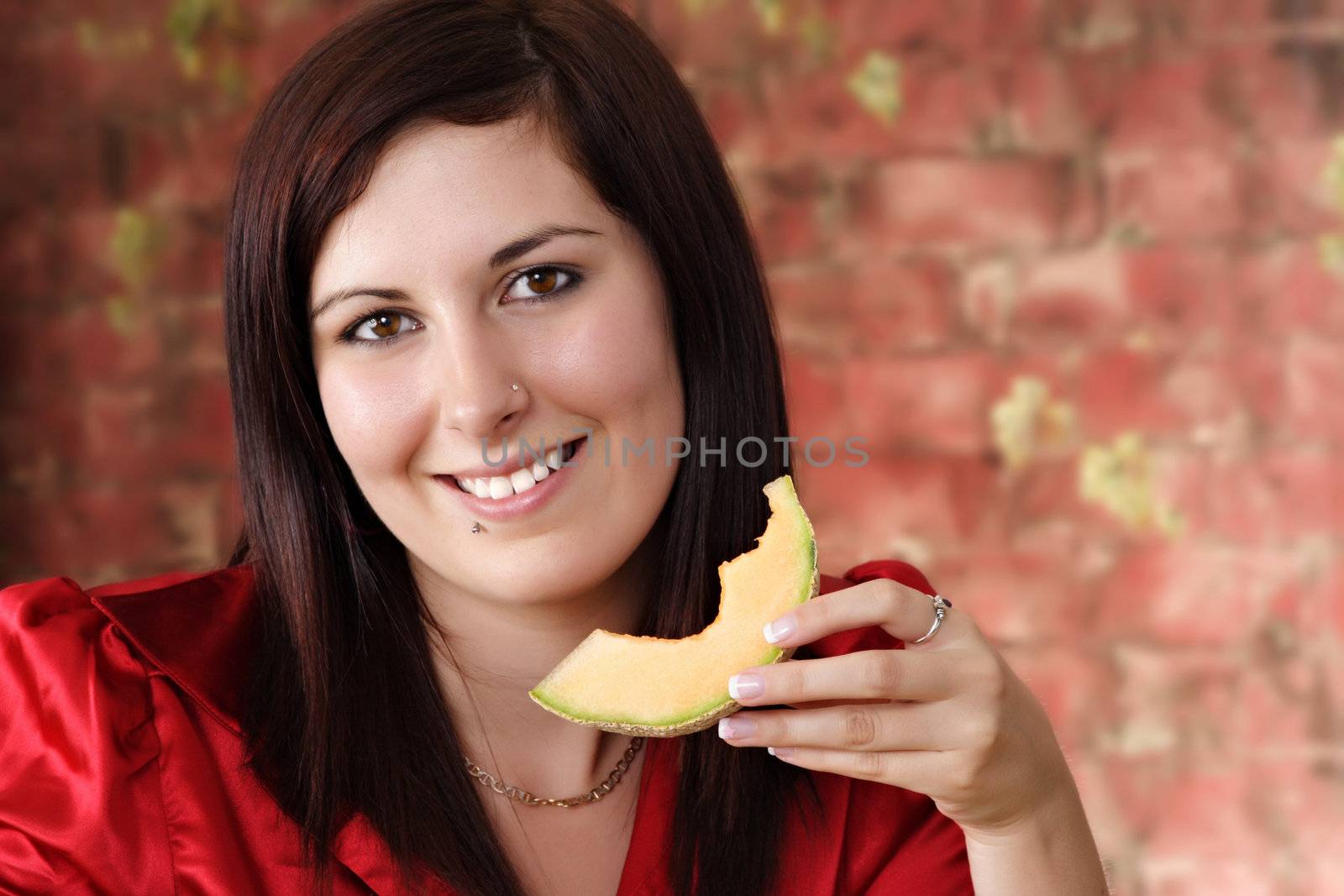 young beautiful woman eating a piece of cantaloup