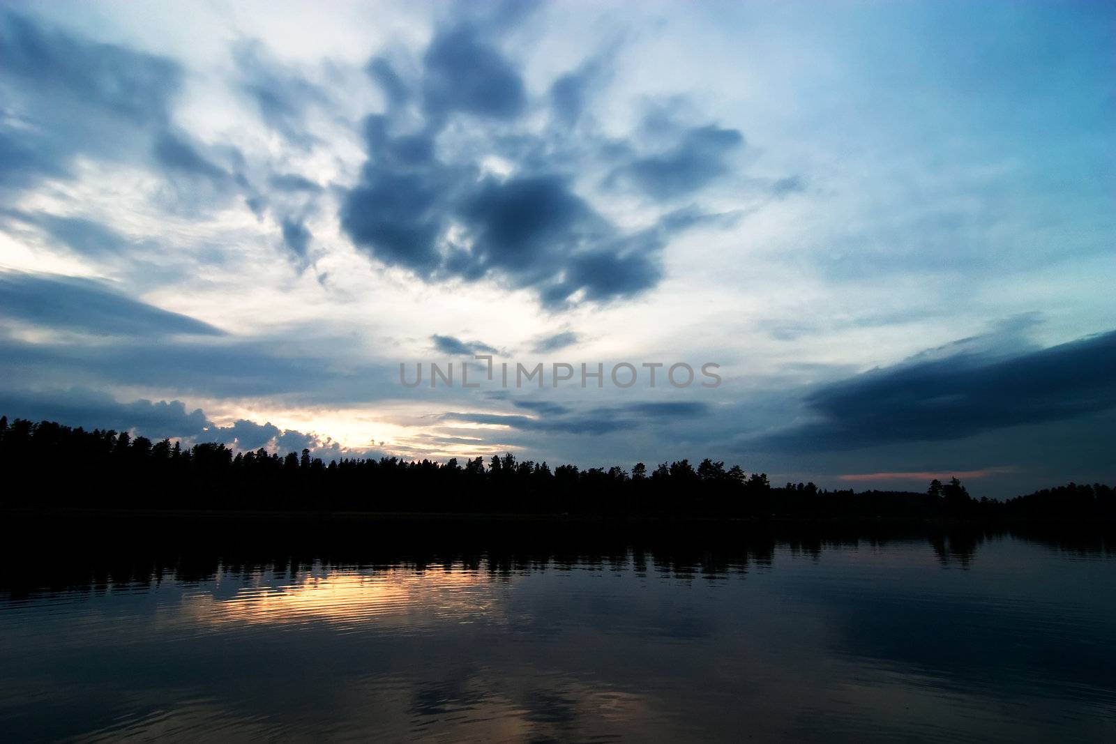 A lake in the evening with a dramtic sky with clodus