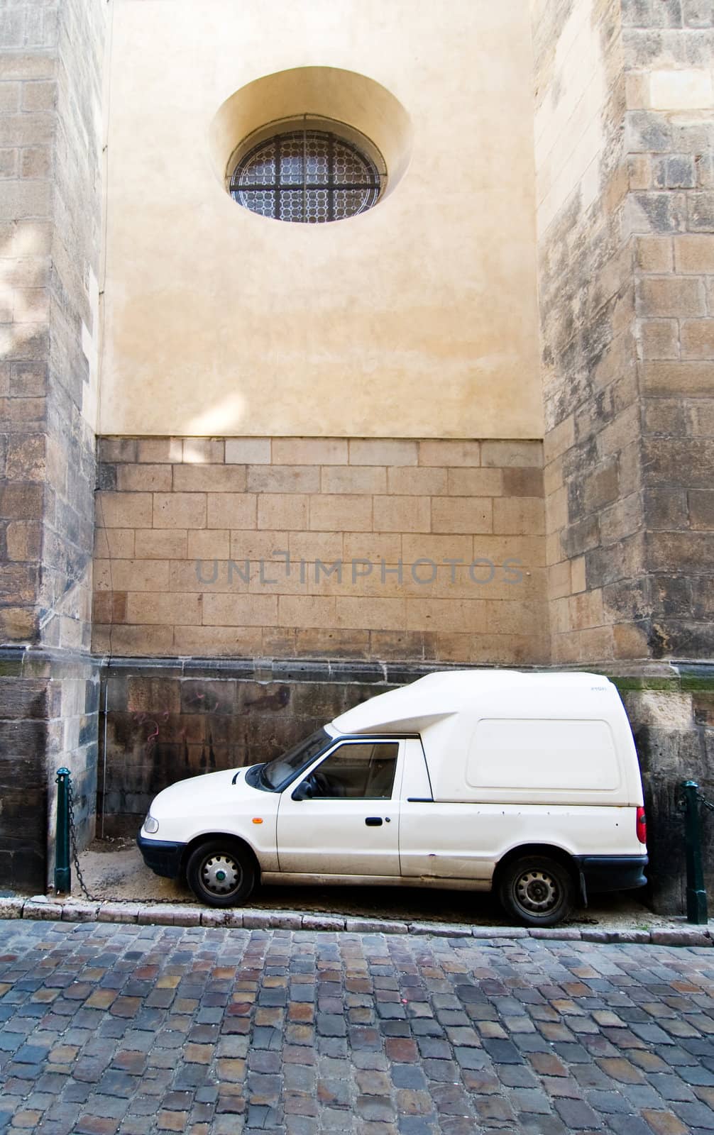 A humorous image of a cargo truck parked between two large buttresses at the St. Giles Church, Prague, Czech Republic.
