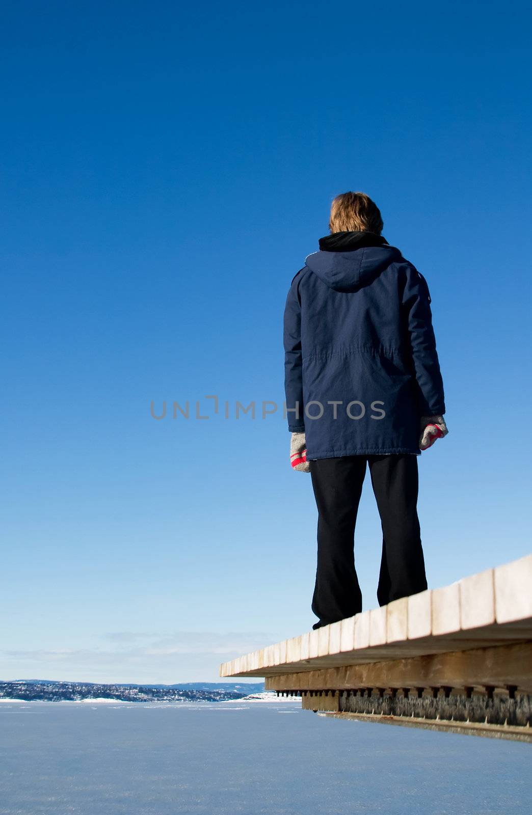 A woman looking over the ocean on the dock