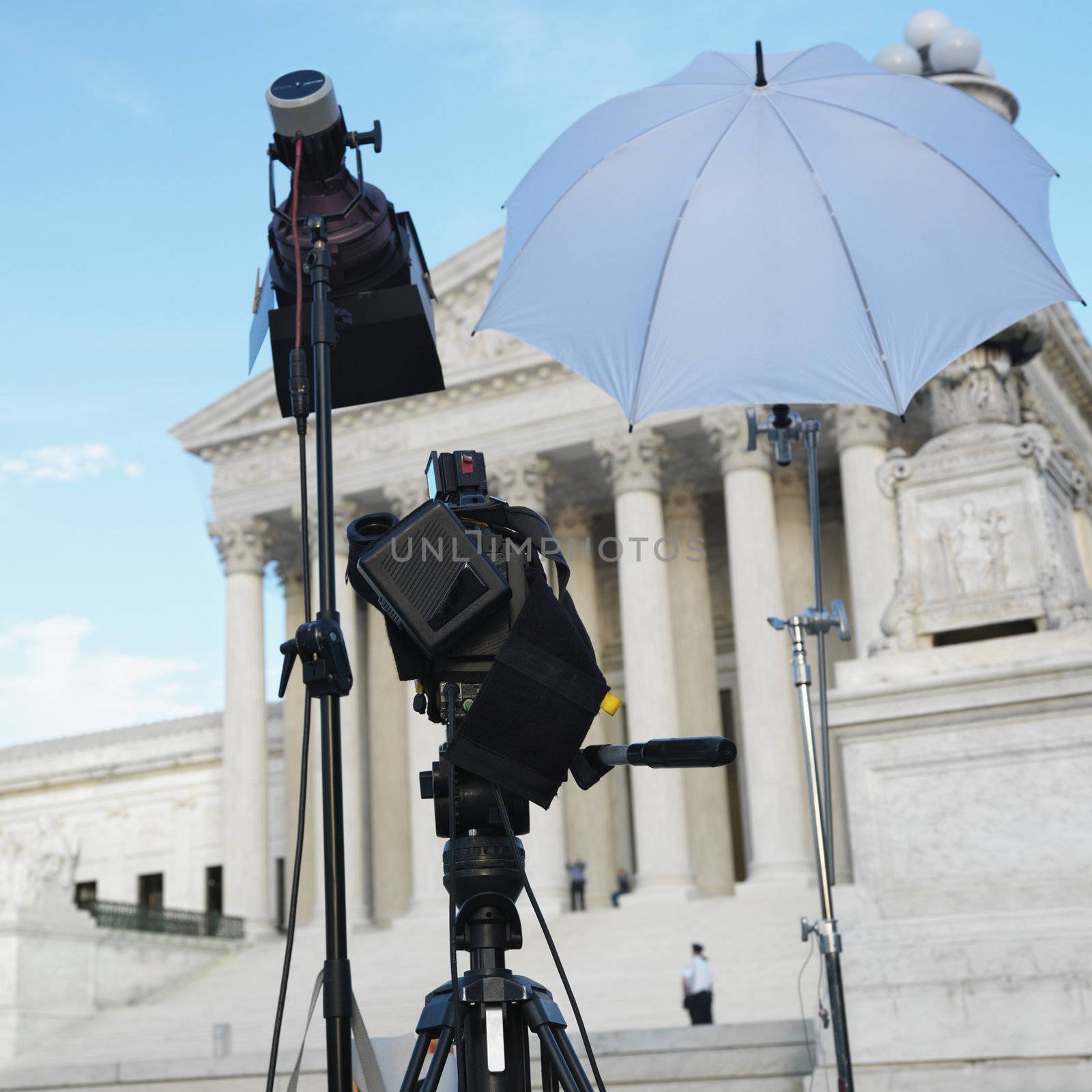 TV production set with camera and lighting equipment on tripods in front of Supreme Court building in Washington DC, USA.