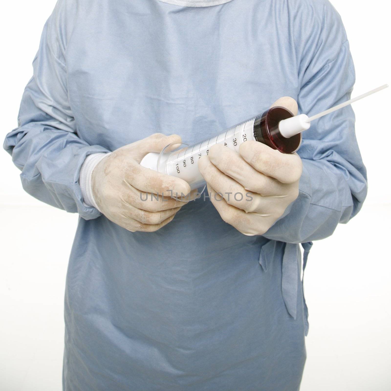 Surgeon holding giant needle. by iofoto