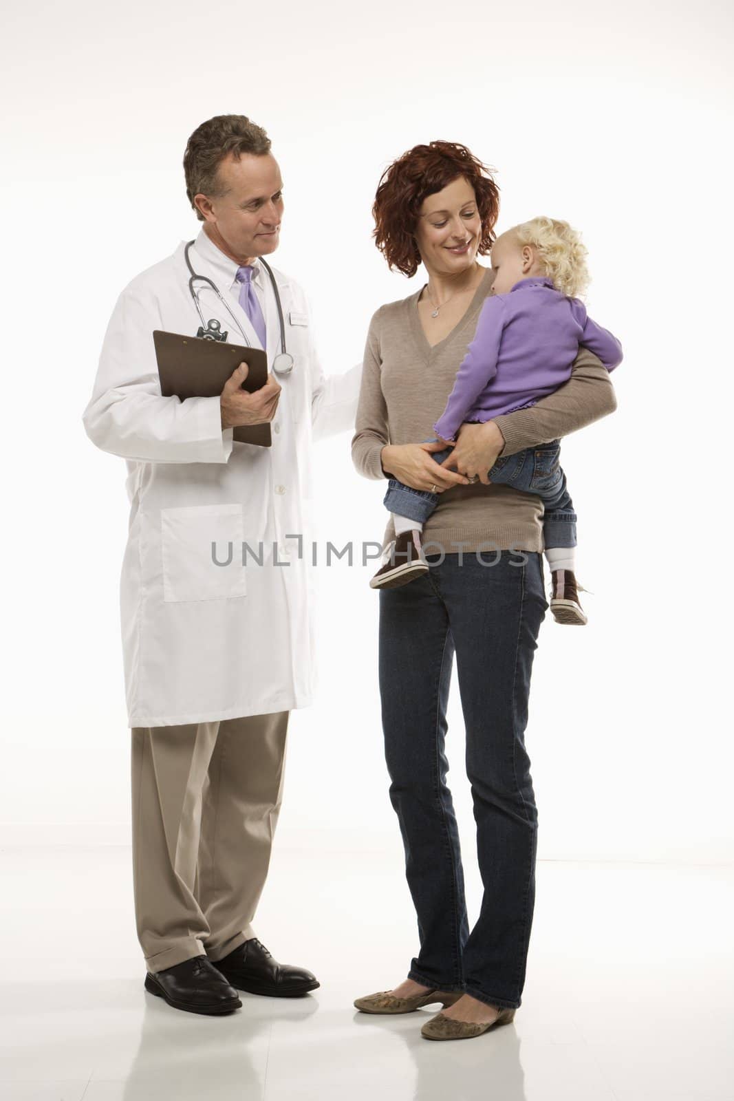Middle-aged adult Caucasian male doctor introducing himself to mid-adult mother and her daughter.