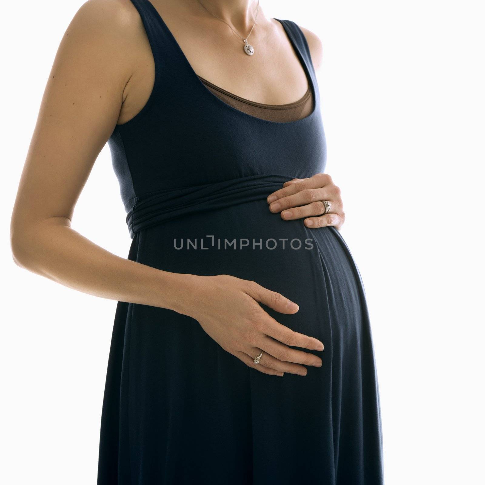 Portrait of Caucasion mid-adult pregnant woman with hands on belly.