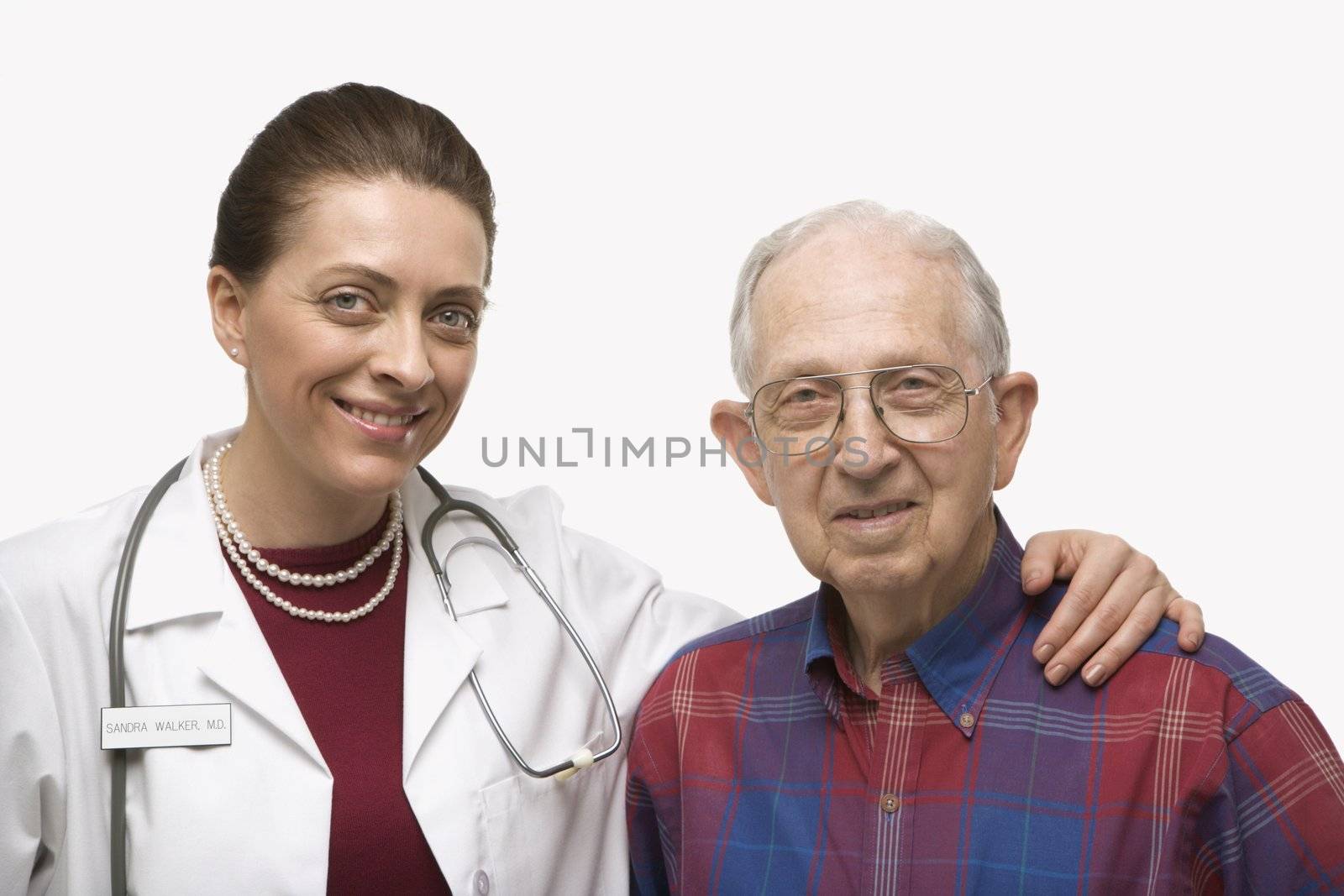 Mid-adult Caucasian female doctor with arm around elderly Caucasian male.
