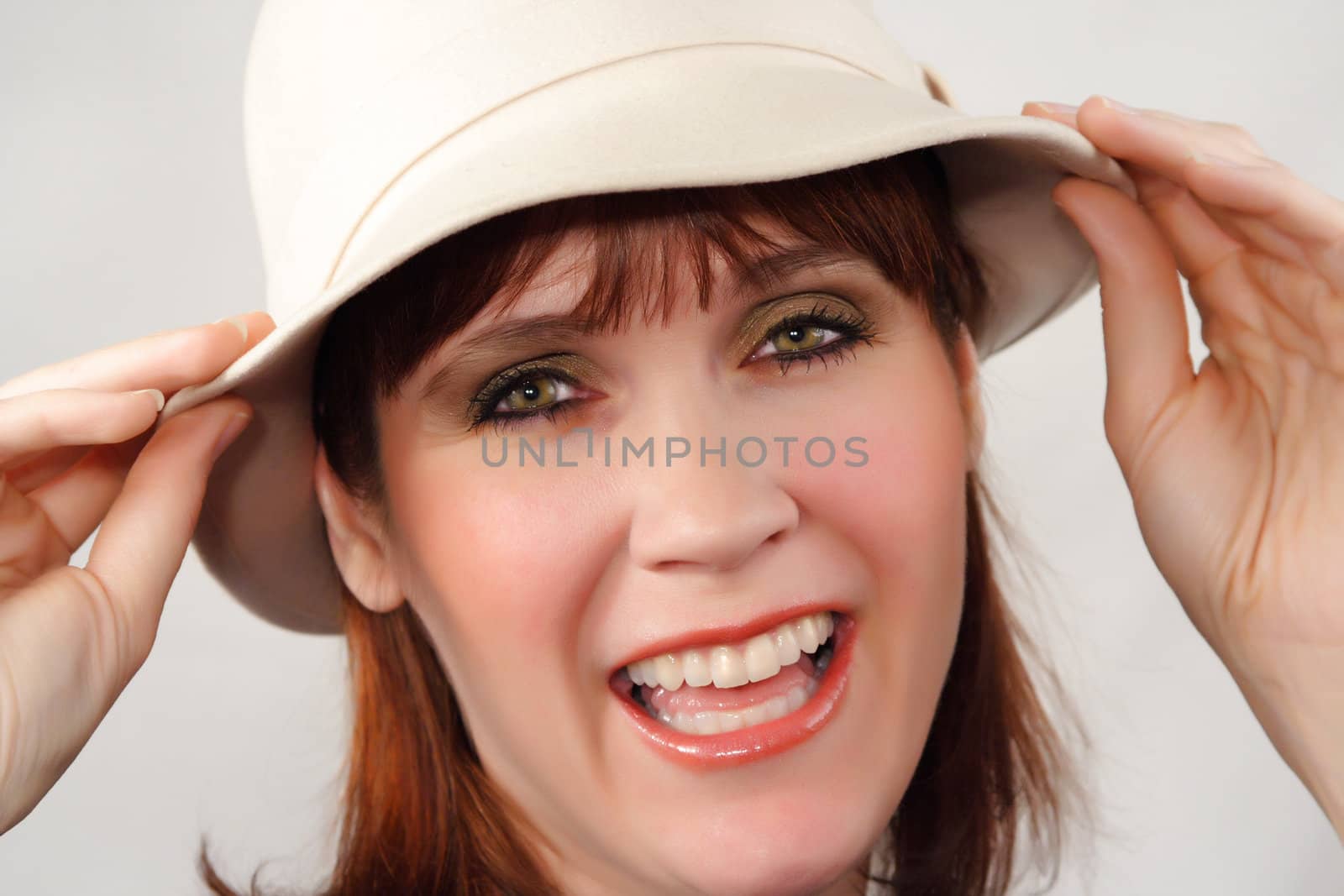 ginger-haired woman with a beige hat