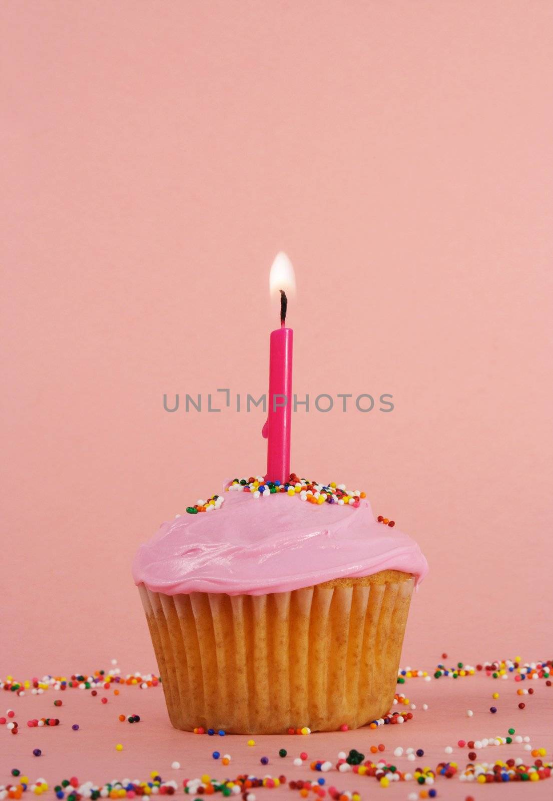 homemade cupcakes with pink icing and candle