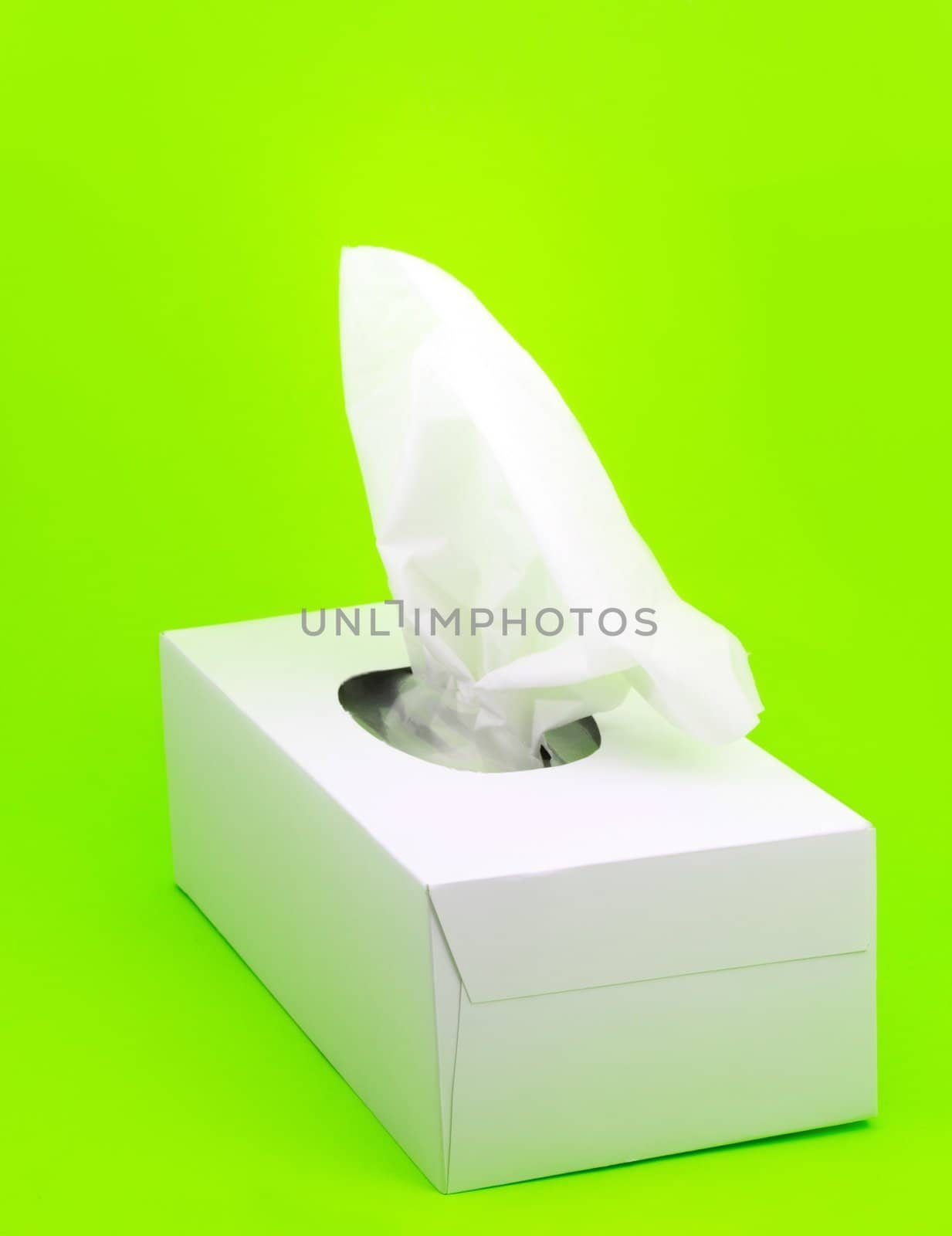 white box of facial tissue on green background