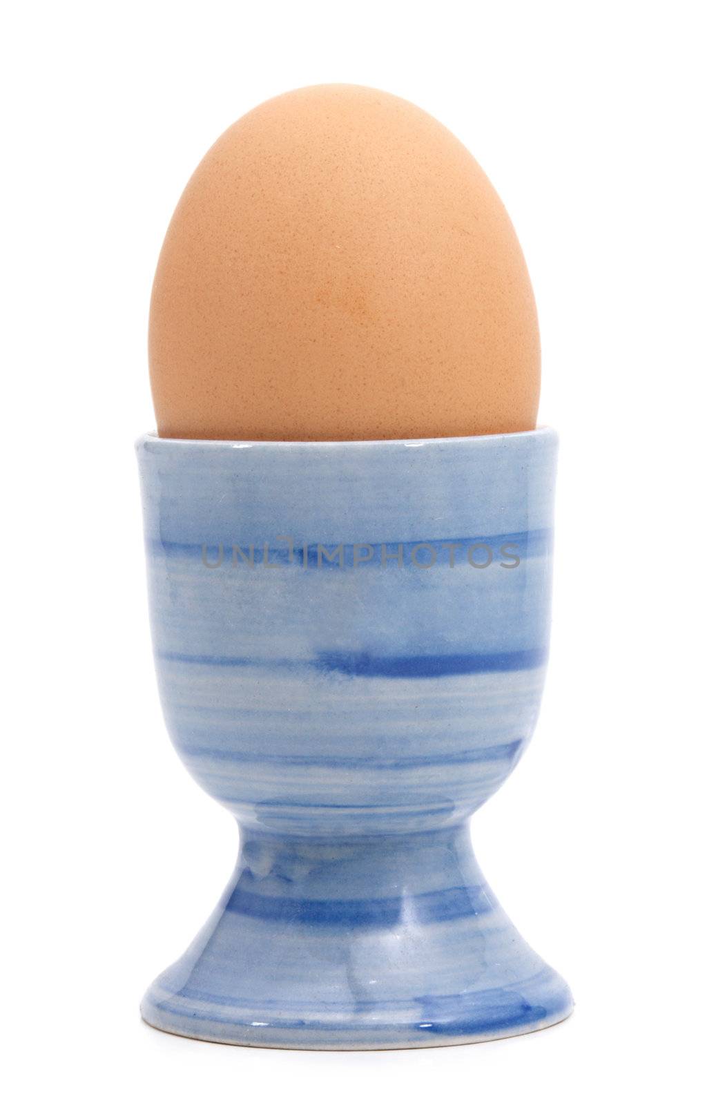 boiled egg on a blue cup, isolated on white