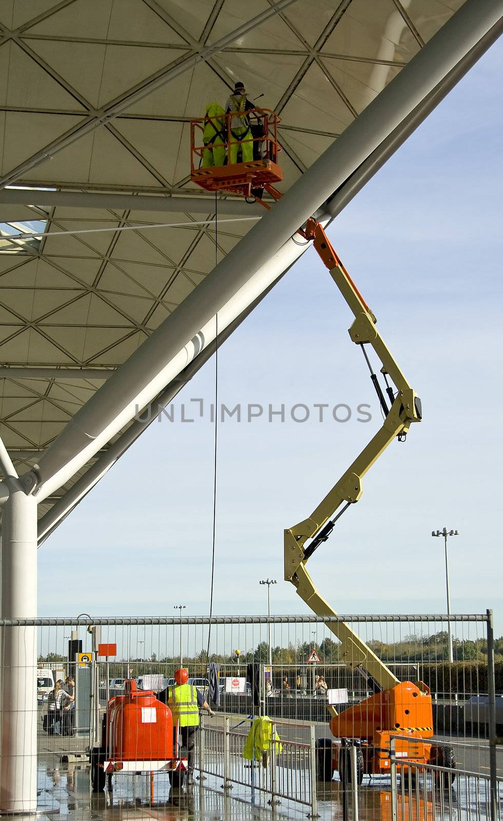 Two workers on a lift, repairing some platform. London, UK.