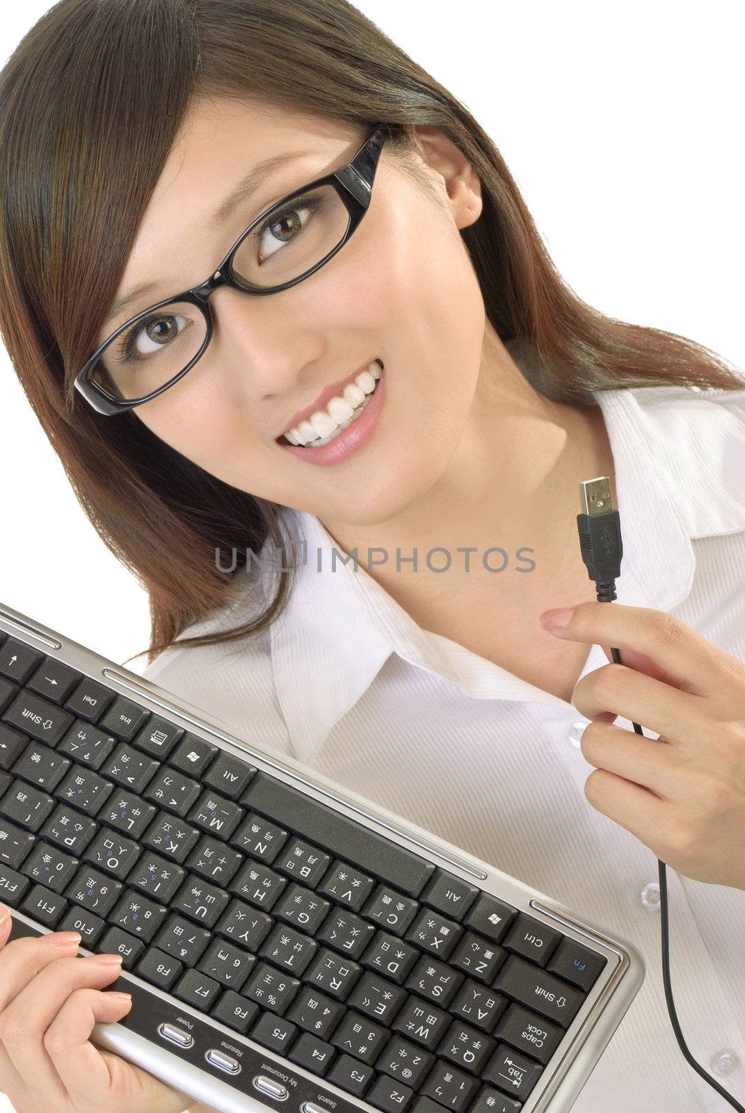 Businesswoman with computer keyboard smiling on white background.