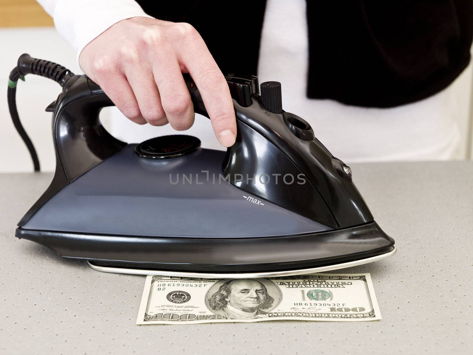 Ironing a hundred dollar bank note