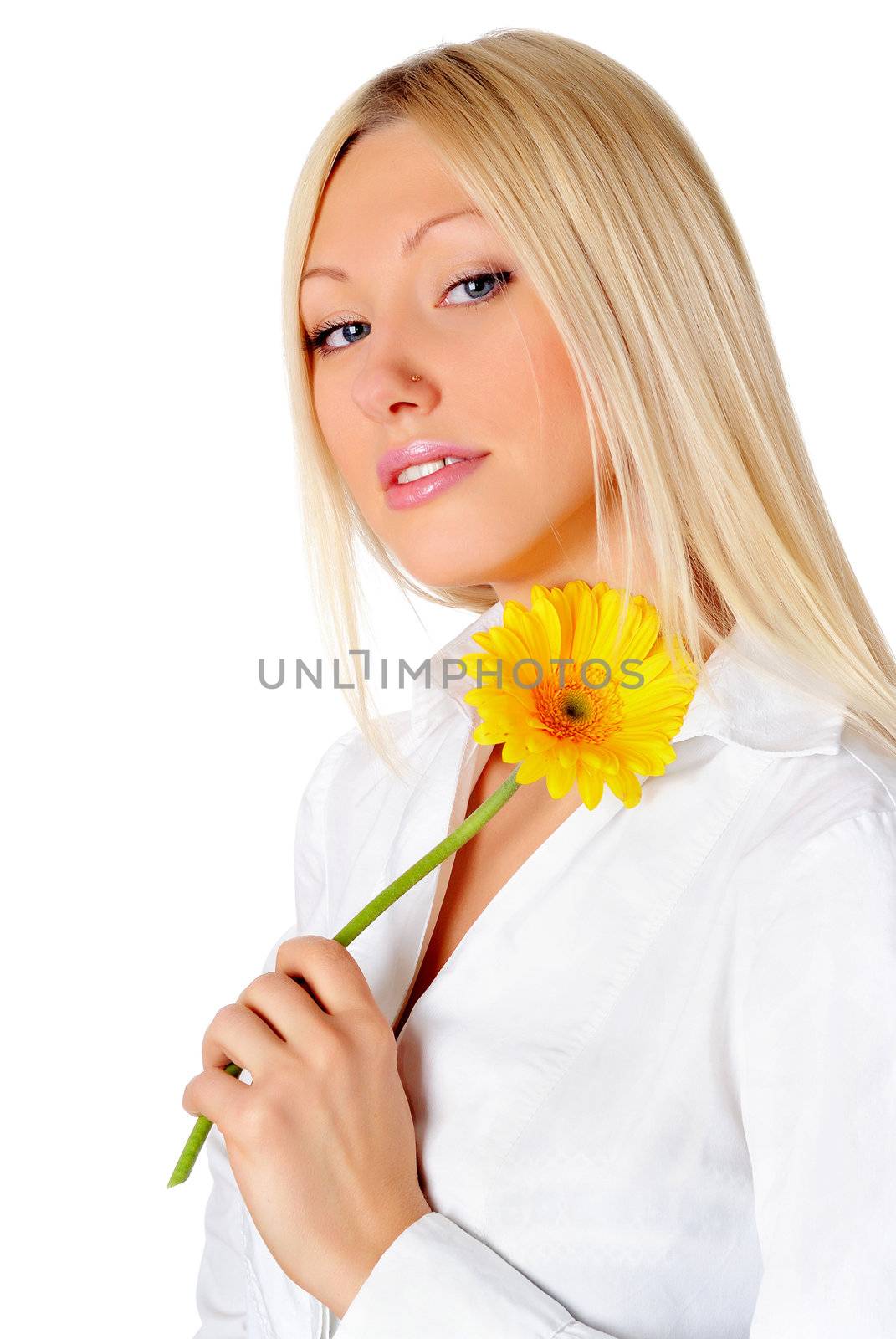 Young smiling blonde in a white shirt plays with a yellow flower in the hands 


