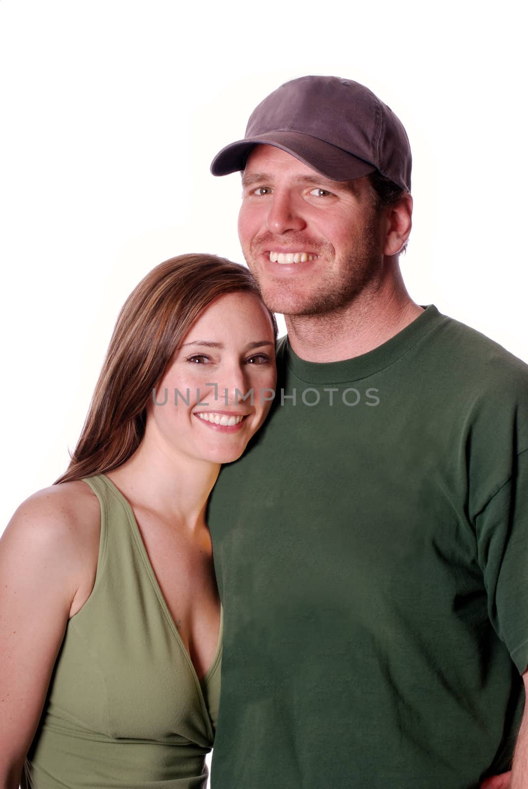 Vertical high key image of an attractive smiling couple, both wearing green tops, against a white background.