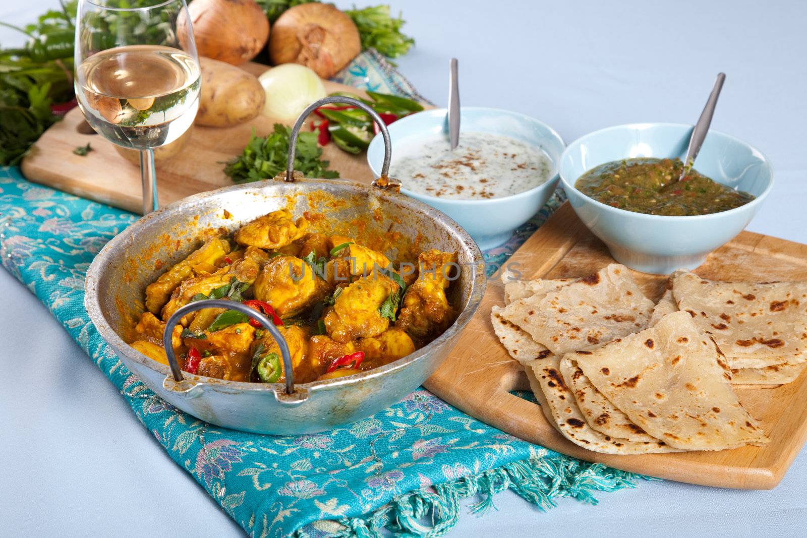 Table with typical Indian dishes such as Indian curry, roti and dips