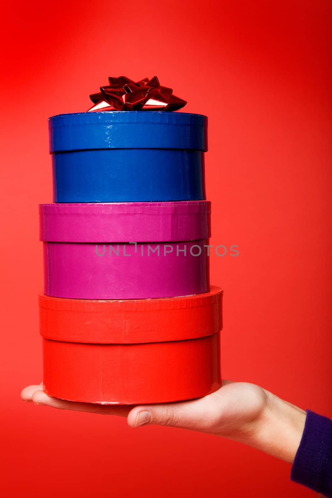 A stack of three gifts isolated on red with room for copy space
